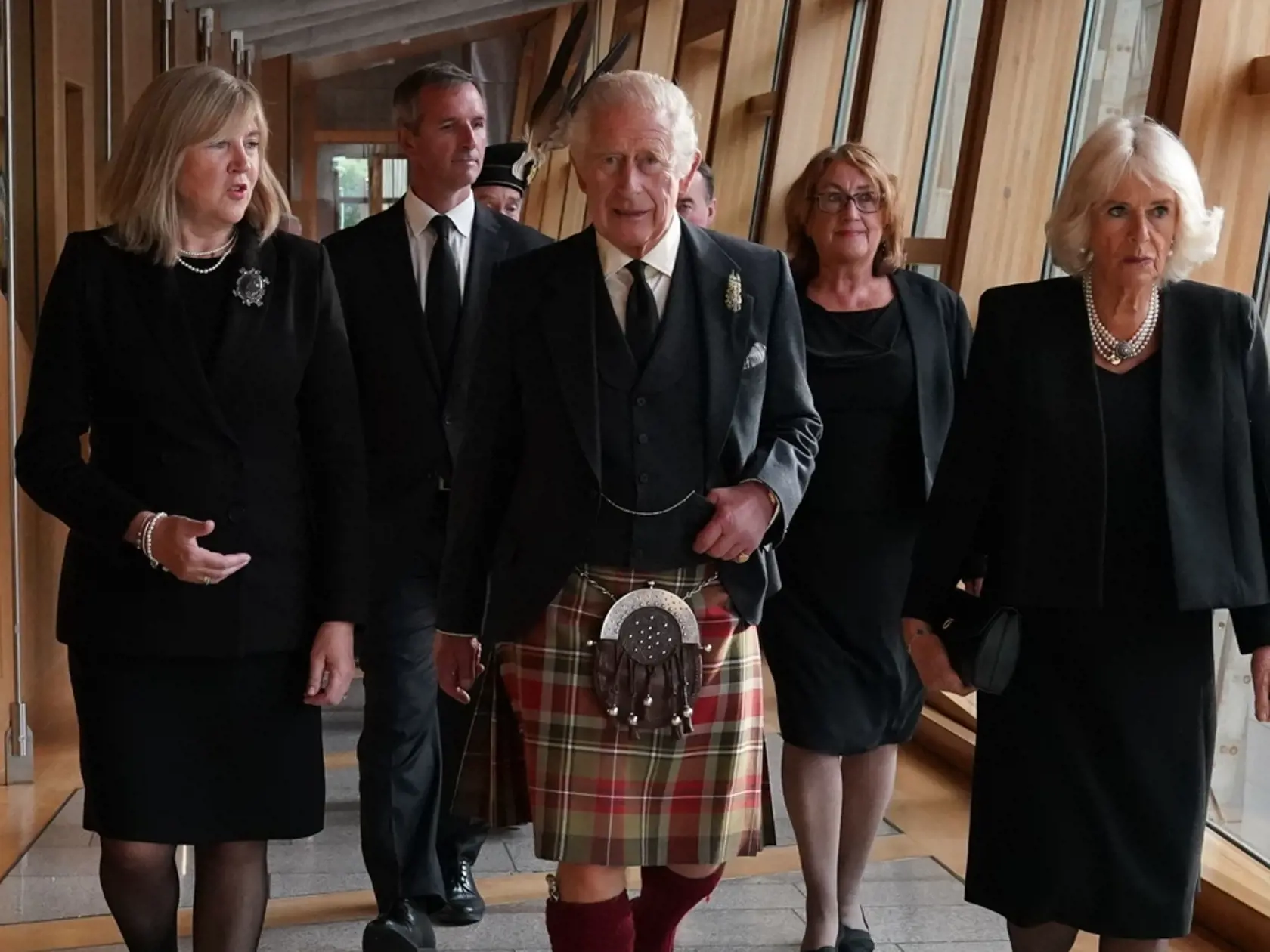 Britský kráľ Charles III. (uprostred), jeho manželka Camilla (vpravo) a predsedníčka škótskeho parlamentu Alison Johnstoneová (vľavo) kráčajú na pôde škótskeho parlamentu v Edinburghu v pondelok 12. septembra 2022.
