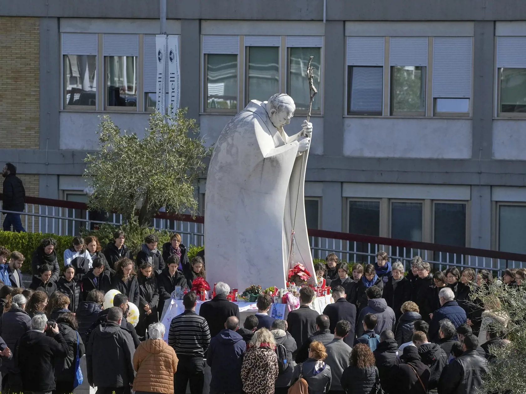 Veriaci sa modlia za zdravie pápeža Františka pri soche Jána Pavla II. pri poliklinike, kde je pápež hospitalizovaný v Ríme 2. marca 2025.