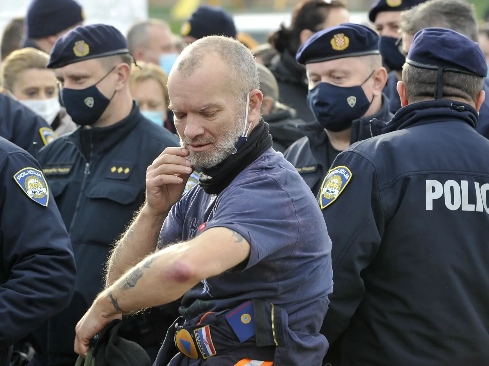 KK18  Petrinja - Záchranár si kontroluje svoje rameno po zaočkovaní vakcínou proti novému koronavírusu, za ním čakajú na očkovanie policajti, 2. januára 2021 v chorvátskom meste Petrinja. Chorvátsko držalo v sobotu štátny smútok, ktorý vyhlásila vláda po utorkovom zemetrasení s magnitúdou 6,2 v strednej časti krajiny. Katastrofa si vyžiadala sedem ľudských životov a ďalšie desiatky ranených a spôsobila obrovské škody. FOTO TASR/AP
A rescuer inspects his arm as members of rescue services and poli