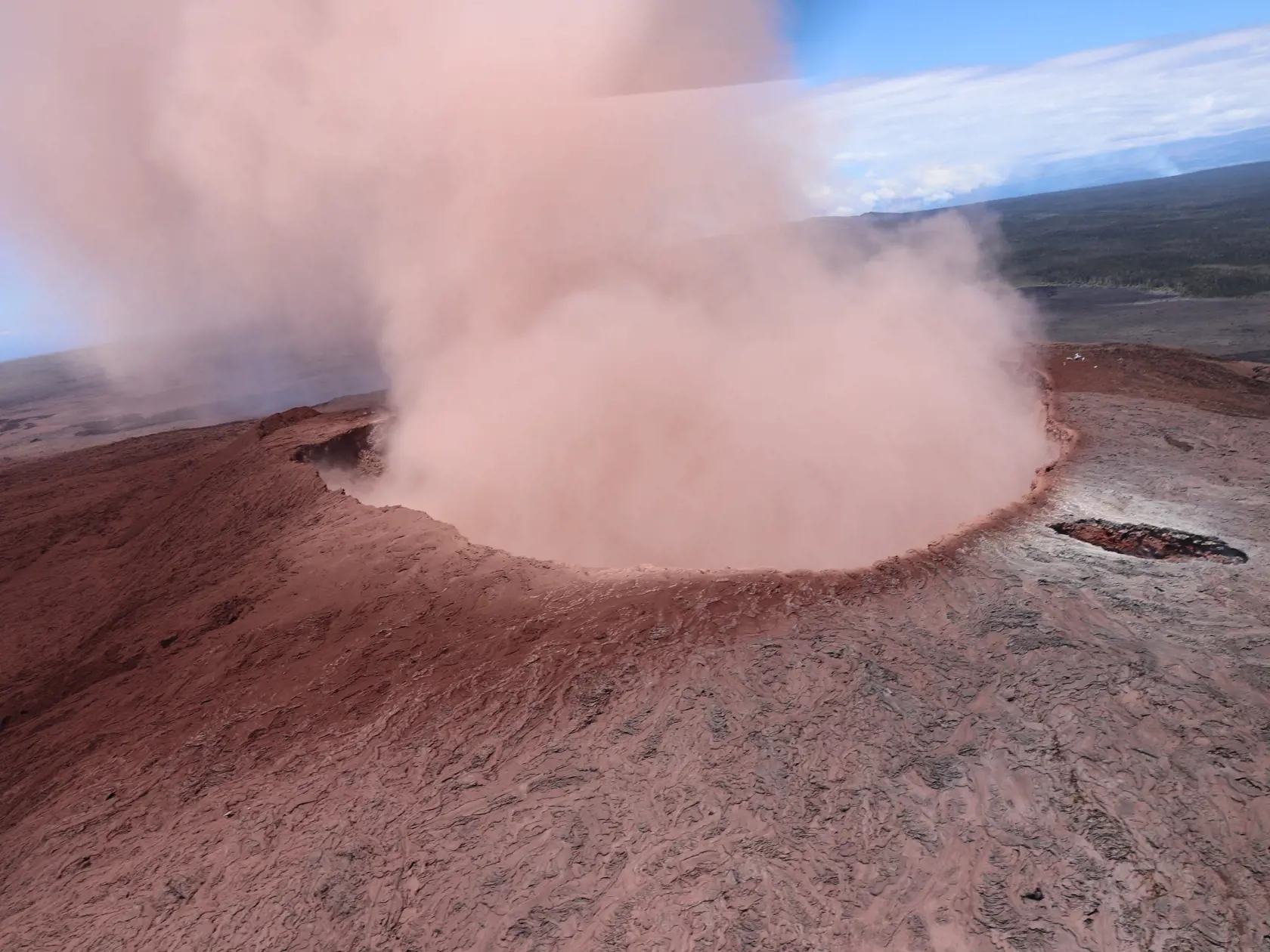 In this photo released by U.S. Geological Survey,  a plume of ash rises from the Puu Oo crater on Hawaii's Kilaueaa Volcano, Thursday, May 3, 2018 in Hawaii Volcanoes National Park. Hawaii's Kilauea volcano erupted Thursday, sending lava shooting into the air in a residential neighborhood and prompting mandatory evacuation orders for nearby homes. Hawaii County said steam and lava poured out of a crack in Leilani Estates, which is near the town of Pahoa on the Big Island. (U.S. Geolgogical Surve