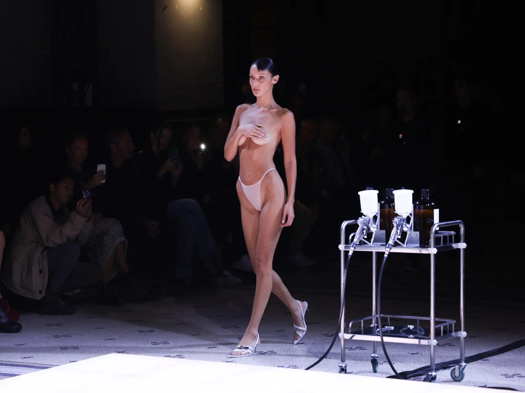 Na prehliadke francúzskej značky Coperni vystúpila v rámci Parížskeho týždňa módy aj takmer úplne holá Bella Hadid. Intímne partie jej zakrývali len skromné nohavičky a prsia si sama prekryla rukou. Ohromení hostia sledovali, čo sa asi bude diať, keďže šaty, ktoré mala kráska predviesť, neboli v dohľade. Keď však na jej  zvodné krivky začali aplikovať bielu farbu, všetci pochopili, čo sa deje - garderóba teraz nepochádza z krajčírskej dielne, ale "plechovky"!