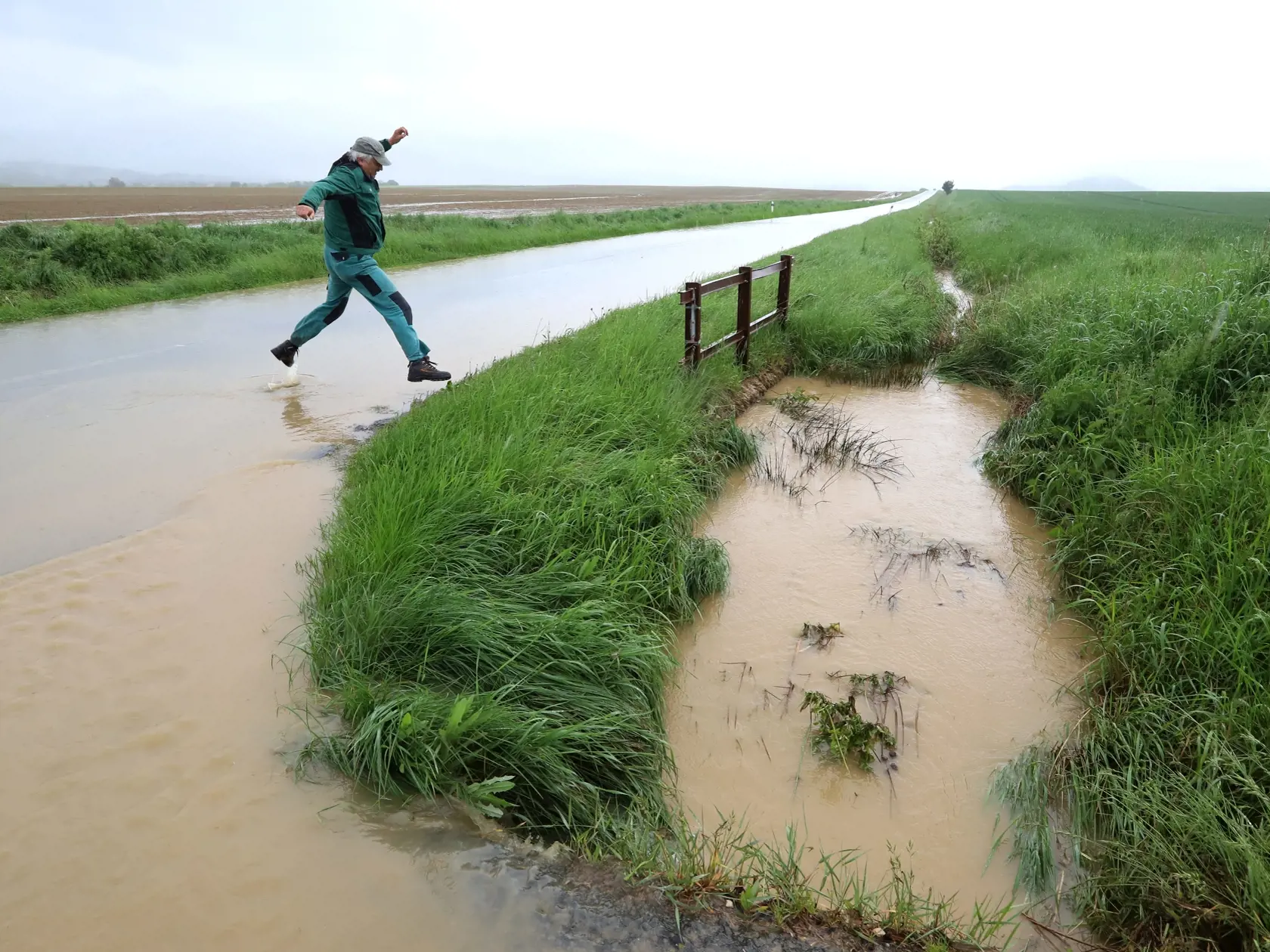 Na väčšine územia Slovenska platia až do stredy výstrahy pred dažďom prvého a druhého stupňa. Slovenský hydrometeorologický ústav (SHMÚ) varuje aj pred povodňami, najmä na západnom a strednom Slovensku. Na snímke úsek cesty Očová - Dúbrava, kde sa cez cestu valí masívne množstvo vody a blata z okolitých polí. Okres Zvolen, 17. mája 2023. FOTO TASR - Ján Krošlák