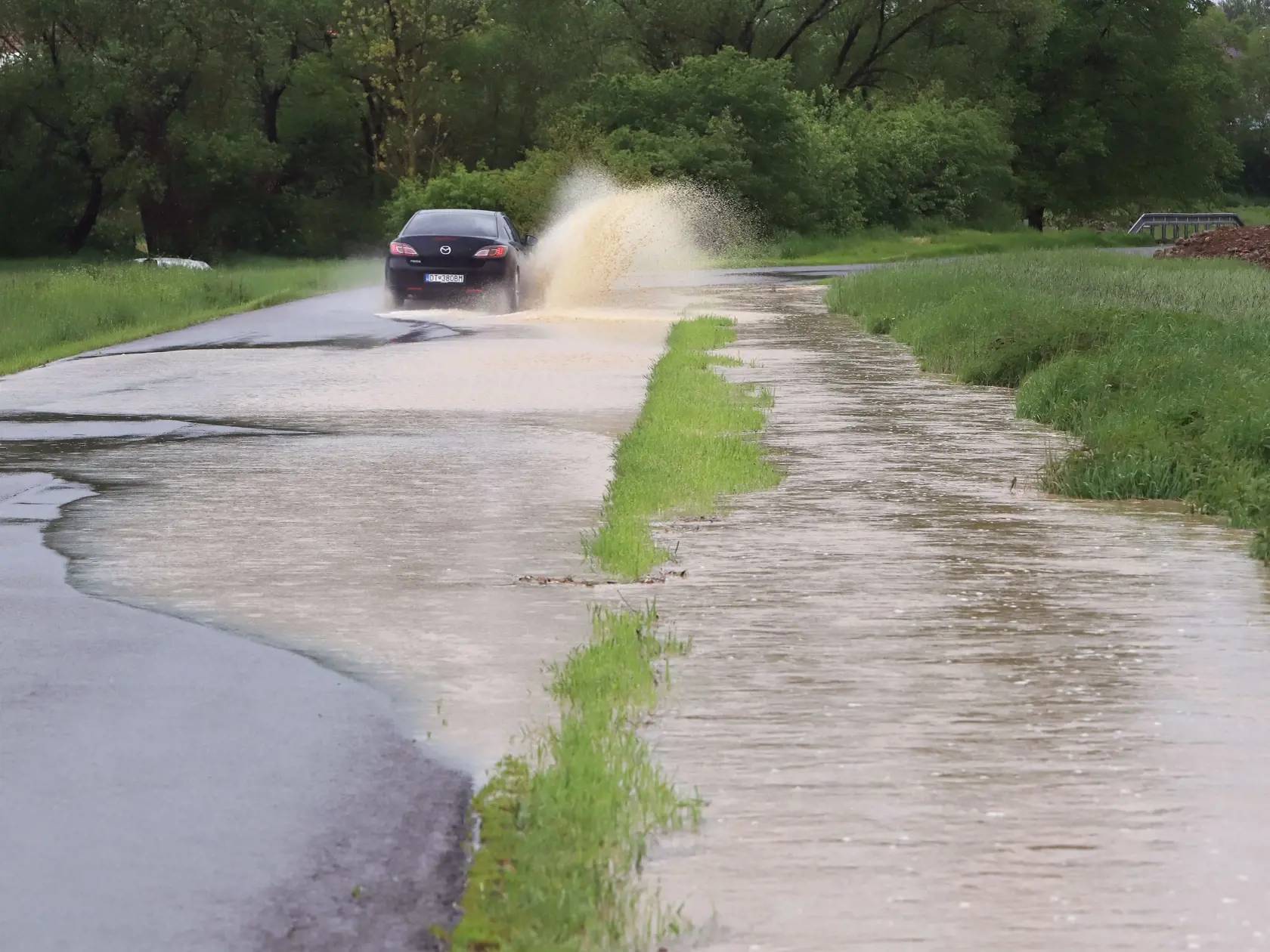 Na väčšine územia Slovenska platia až do stredy výstrahy pred dažďom prvého a druhého stupňa. Slovenský hydrometeorologický ústav (SHMÚ) varuje aj pred povodňami, najmä na západnom a strednom Slovensku. Na snímke úsek cesty Očová - Dúbrava, kde sa cez cestu valí masívne množstvo vody a blata z okolitých polí. Okres Zvolen, 17. mája 2023. FOTO TASR - Ján Krošlák