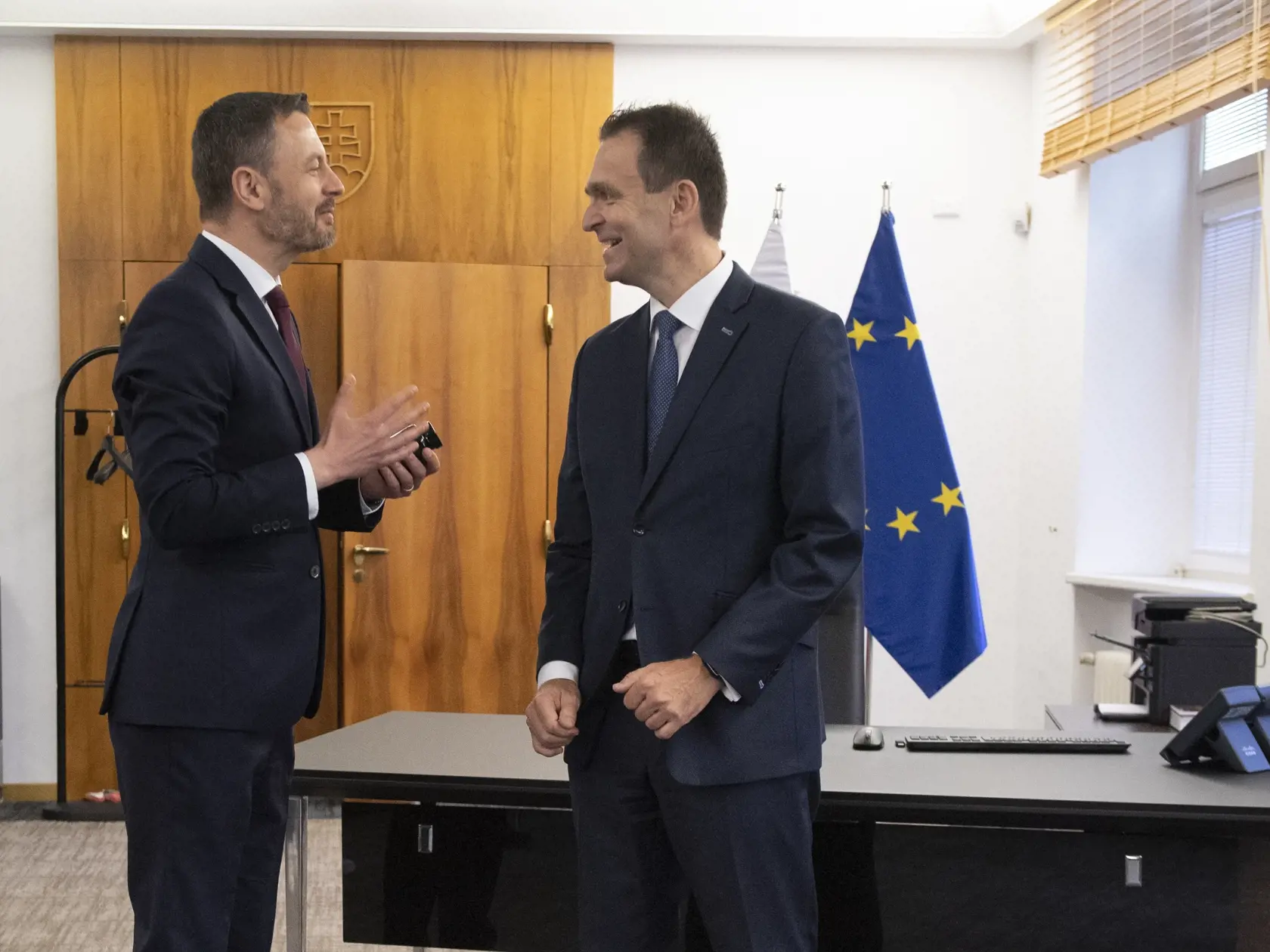 Na snímke vpravo nový predseda vlády SR Ľudovít Ódor stojí v pracovni premiéra na Úrade vlády SR, kde ho privítal jeho predchodca Eduard Heger (vľavo) počas odovzdania Úradu vlády SR v Bratislave 15. mája 2023. Nový premiér Ľudovít Ódor si v pondelok prevzal od svojho predchodcu Eduarda Hegera Úrad vlády SR. Urobil tak potom, ako ho prezidentka SR Zuzana Čaputová vymenovala do funkcie. Ódor je na čele vlády odborníkov, ktorá vystriedala dočasne poverený kabinet Eduarda Hegera. FOTO TASR - Pavel 