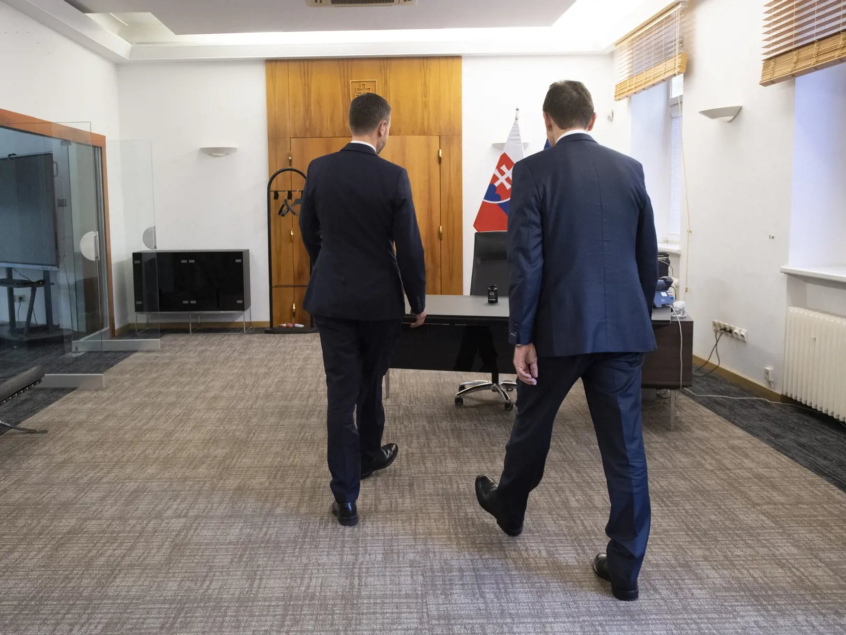 Na snímke vpravo nový predseda vlády SR Ľudovít Ódor kráča v pracovni premiéra na Úrade vlády SR, kde ho privítal jeho predchodca Eduard Heger (vľavo) počas odovzdania Úradu vlády SR v Bratislave 15. mája 2023. Nový premiér Ľudovít Ódor si v pondelok prevzal od svojho predchodcu Eduarda Hegera Úrad vlády SR. Urobil tak potom, ako ho prezidentka SR Zuzana Čaputová vymenovala do funkcie. Ódor je na čele vlády odborníkov, ktorá vystriedala dočasne poverený kabinet Eduarda Hegera. FOTO TASR - Pavel 