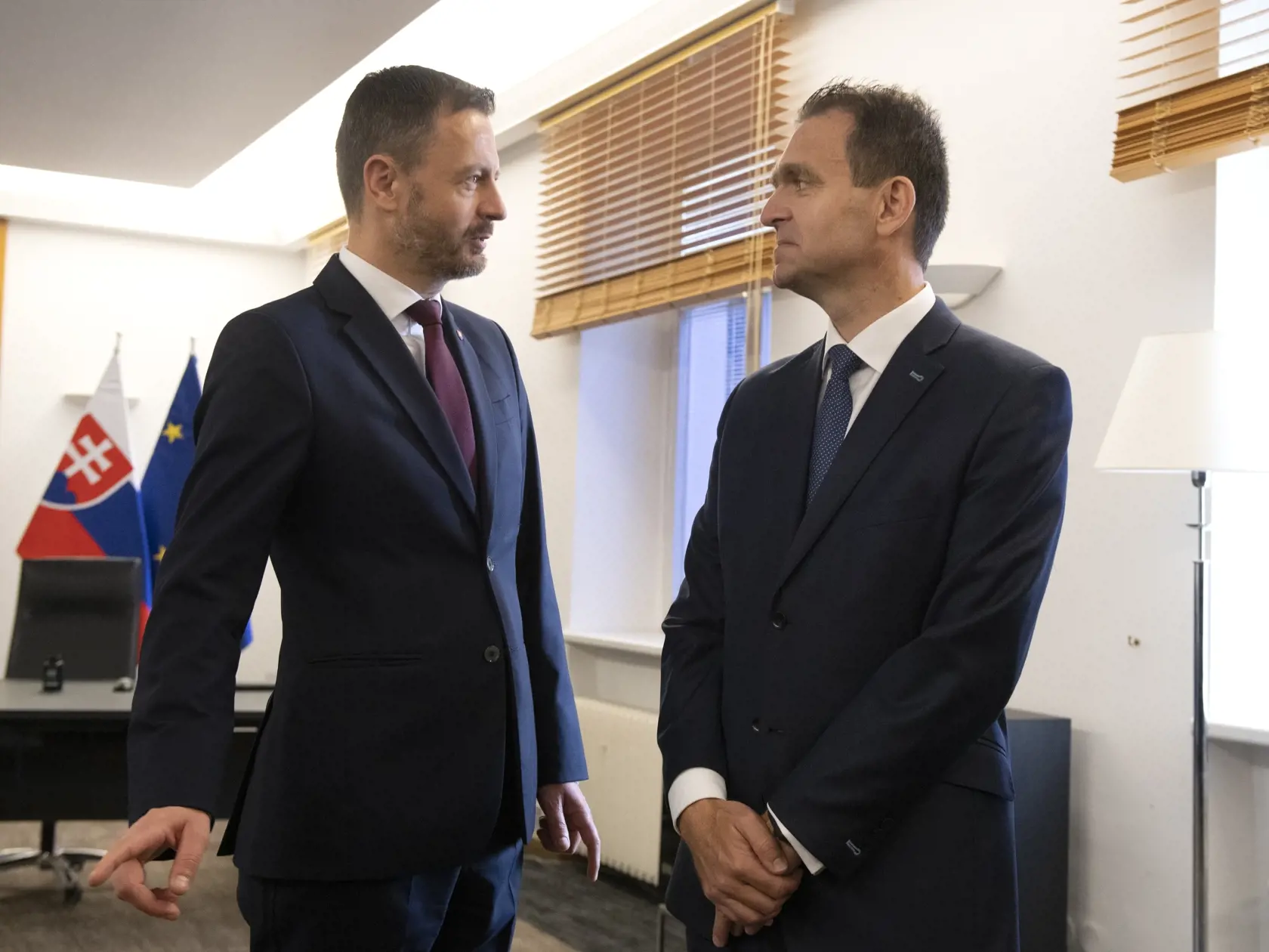 Na snímke vpravo nový predseda vlády SR Ľudovít Ódor stojí v pracovni premiéra na Úrade vlády SR, kde ho privítal jeho predchodca Eduard Heger (vľavo) počas odovzdania Úradu vlády SR v Bratislave 15. mája 2023. Nový premiér Ľudovít Ódor si v pondelok prevzal od svojho predchodcu Eduarda Hegera Úrad vlády SR. Urobil tak potom, ako ho prezidentka SR Zuzana Čaputová vymenovala do funkcie. Ódor je na čele vlády odborníkov, ktorá vystriedala dočasne poverený kabinet Eduarda Hegera. FOTO TASR - Pavel 