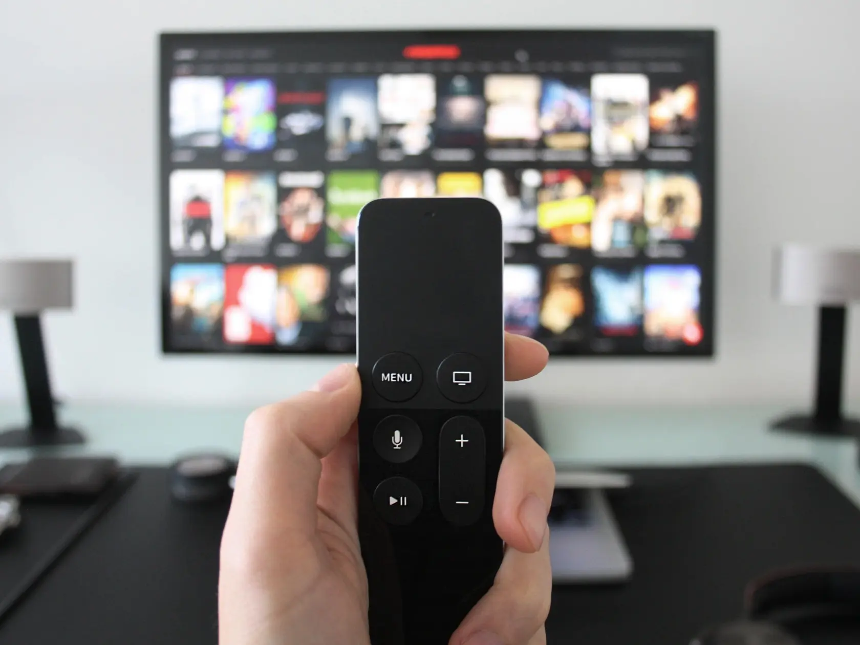 Hand,Holding,A,Tv,Remote,While,Watching,Shows,On,A