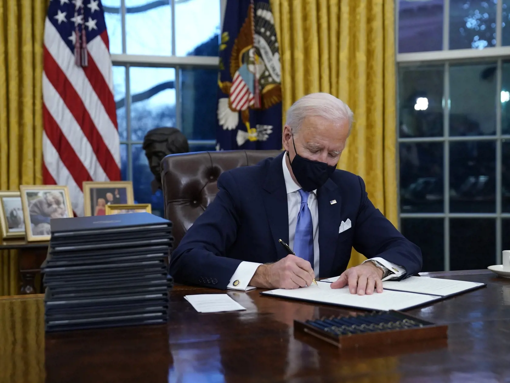 KK6 Washington - Americký prezident Joe Biden podpisuje prvé dokumenty v Oválnej pracovni Bieleho domu 20. januára 2021 vo Washingtone.  Biden začal úradovať prakticky okamžite po nástupe do funkcie. Celkovo podpísal dovedna 15 výkonných nariadení týkajúcich sa najmä ochrany klímy, imigrácie, boja proti novému koronavírusu či ekonomickej situácii v krajine. FOTO TASR/AP 
President Joe Biden signs his first executive orders in the Oval Office of the White House on Wednesday, Jan. 20, 2021, in Was