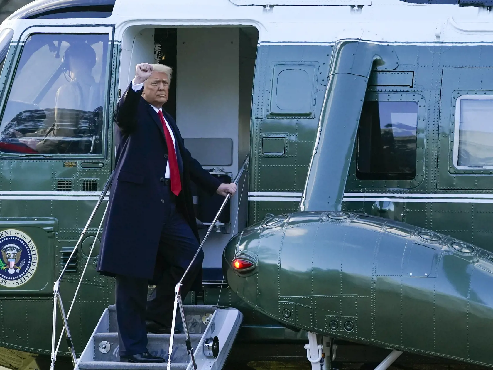 KK49 Washington - Odchádzajúci americký prezident Donald Trump máva z vrtuľníka Marine One počas odchodu z Bieleho domu 20. januára 2021 vo Washingtone. Donald Trump je na ceste do svojho sídla Mar-a-Lago na Floride. FOTO TASR/AP
President Donald Trump gestures as he boards Marine One on the South Lawn of the White House, Wednesday, Jan. 20, 2021, in Washington. Trump is en route to his Mar-a-Lago Florida Resort. (AP Photo/Alex Brandon)