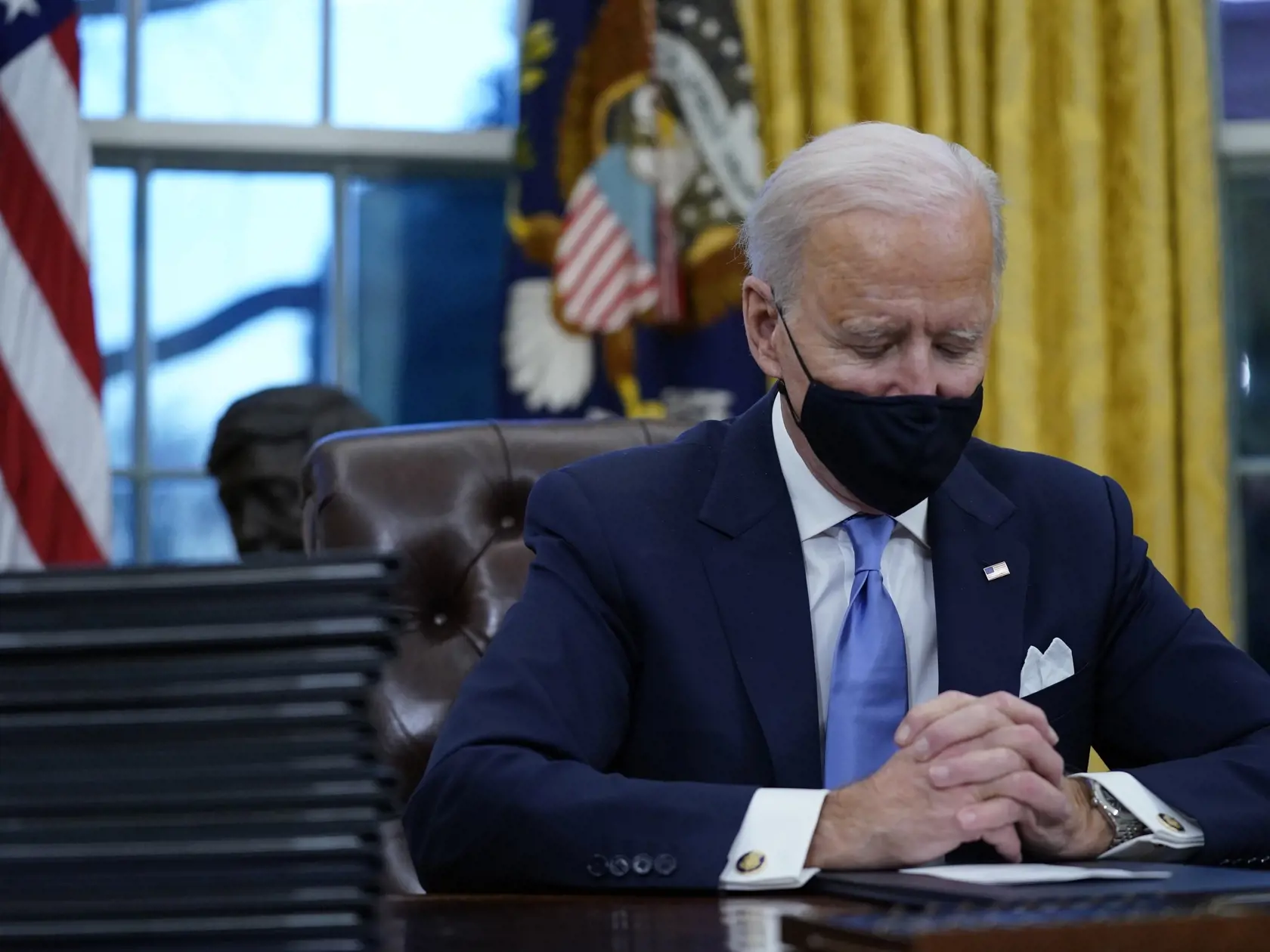KK8 Washington - Americký prezident Joe Biden sa pripravuje podpísať prvé dokumenty v Oválnej pracovni Bieleho domu 20. januára 2021 vo Washingtone.  Biden začal úradovať prakticky okamžite po nástupe do funkcie. Celkovo podpísal dovedna 15 výkonných nariadení týkajúcich sa najmä ochrany klímy, imigrácie, boja proti novému koronavírusu či ekonomickej situácii v krajine. FOTO TASR/AP 
President Joe Biden pauses as he signs his first executive orders in the Oval Office of the White House on Wednes