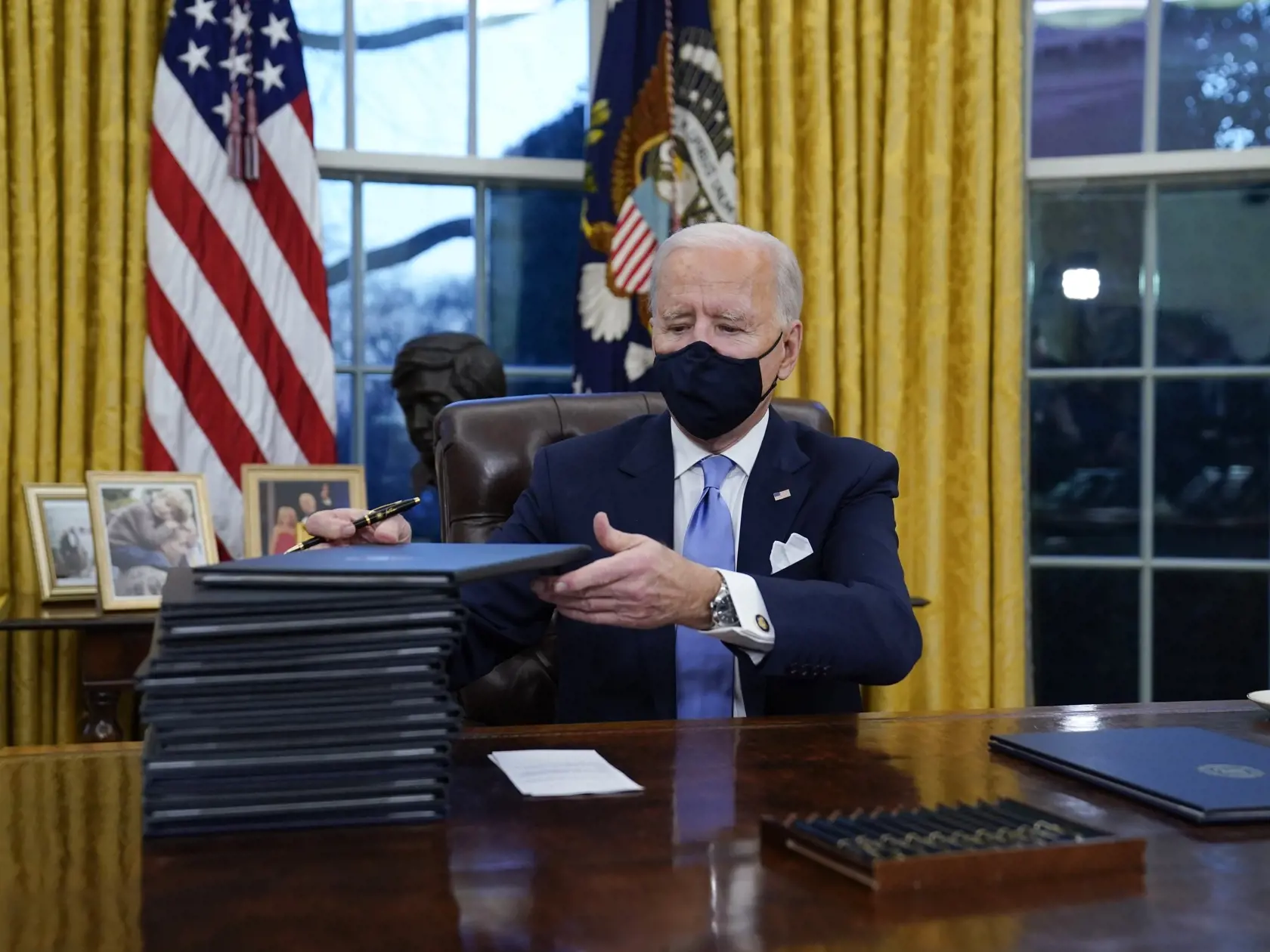 KK5 Washington - Americký prezident Joe Biden podpisuje prvé dokumenty v Oválnej pracovni Bieleho domu 20. januára 2021 vo Washingtone.  Biden začal úradovať prakticky okamžite po nástupe do funkcie. Celkovo podpísal dovedna 15 výkonných nariadení týkajúcich sa najmä ochrany klímy, imigrácie, boja proti novému koronavírusu či ekonomickej situácii v krajine. FOTO TASR/AP 
President Joe Biden signs his first executive orders in the Oval Office of the White House on Wednesday, Jan. 20, 2021, in Was
