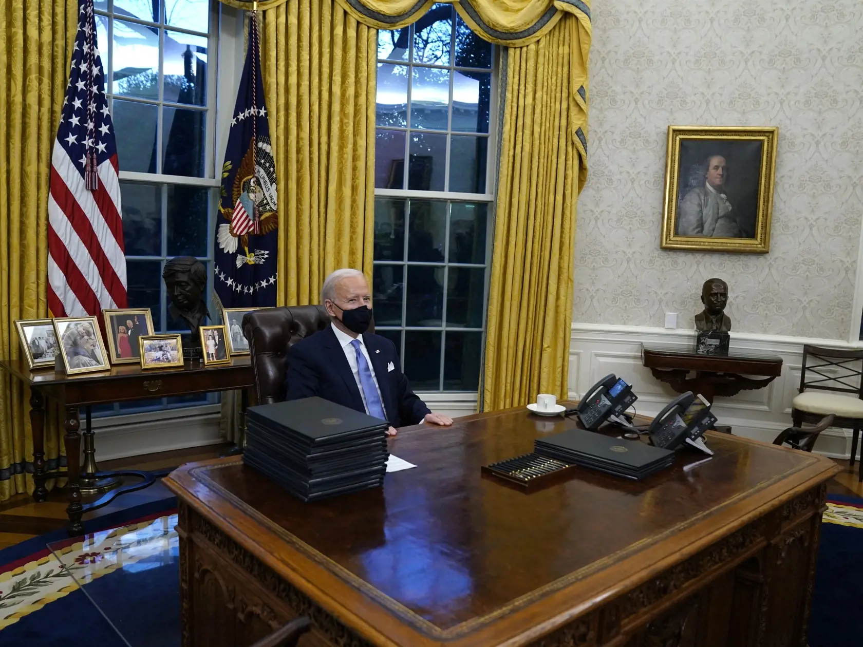 KK7 Washington - Americký prezident Joe Biden podpisuje prvé dokumenty v Oválnej pracovni Bieleho domu 20. januára 2021 vo Washingtone.  Biden začal úradovať prakticky okamžite po nástupe do funkcie. Celkovo podpísal dovedna 15 výkonných nariadení týkajúcich sa najmä ochrany klímy, imigrácie, boja proti novému koronavírusu či ekonomickej situácii v krajine. FOTO TASR/AP 
President Joe Biden pauses as he signs his first executive orders in the Oval Office of the White House on Wednesday, Jan. 20,
