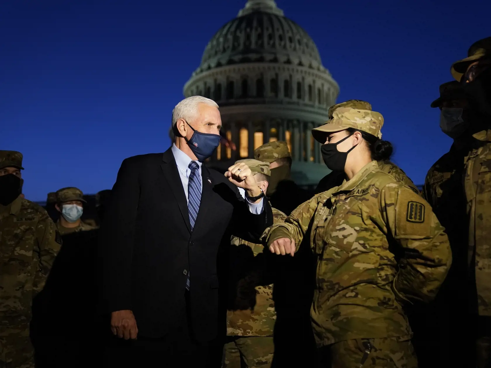 KK30 Washington - Americký viceprezident Mike Pence počas stretnutia s príslušníkmi Národnej gardy pred budovou Kapitolu 14. januára 2021 vo Washingtone. Americký viceprezident Mike Pence vo štvrtok prisľúbil, že zaistí bezpečné odovzdanie moci novozvolenému prezidentovi Joeovi Bidenovi. Uviedol to osem dní po tom, čo do budovy Kongresu Spojených štátov vnikli prívrženci dosluhujúceho šéfa Bieleho domu Donalda Trumpa, píše agentúra Reuters. FOTO TASR/AP
Vice President Mike Pence elbow bumps with