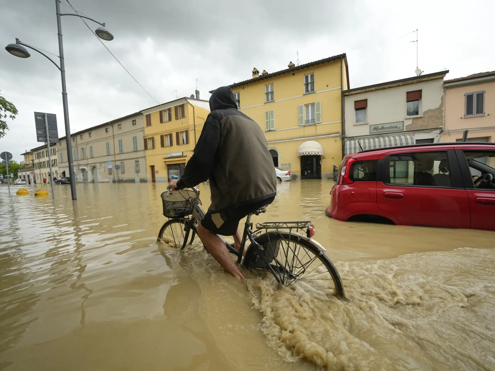 WA 17 Castel Bolognese - Cyklista sa brodí cez zaplavenú ulicu v obci Castel Bolognese v severotalianskom regióne Emilia Romagna v stredu 17. mája 2023. Na najmenej osem stúpol v stredu počet obetí dvojdňových výdatných zrážok a následných záplav na severe Talianska. FOTO TASR/AP

A cyclist rides through a flooded street in the village of Castel Bolognese, Italy, Wednesday, May 17, 2023. Exceptional rains Wednesday in a drought-struck region of northern Italy swelled rivers over their banks, kil