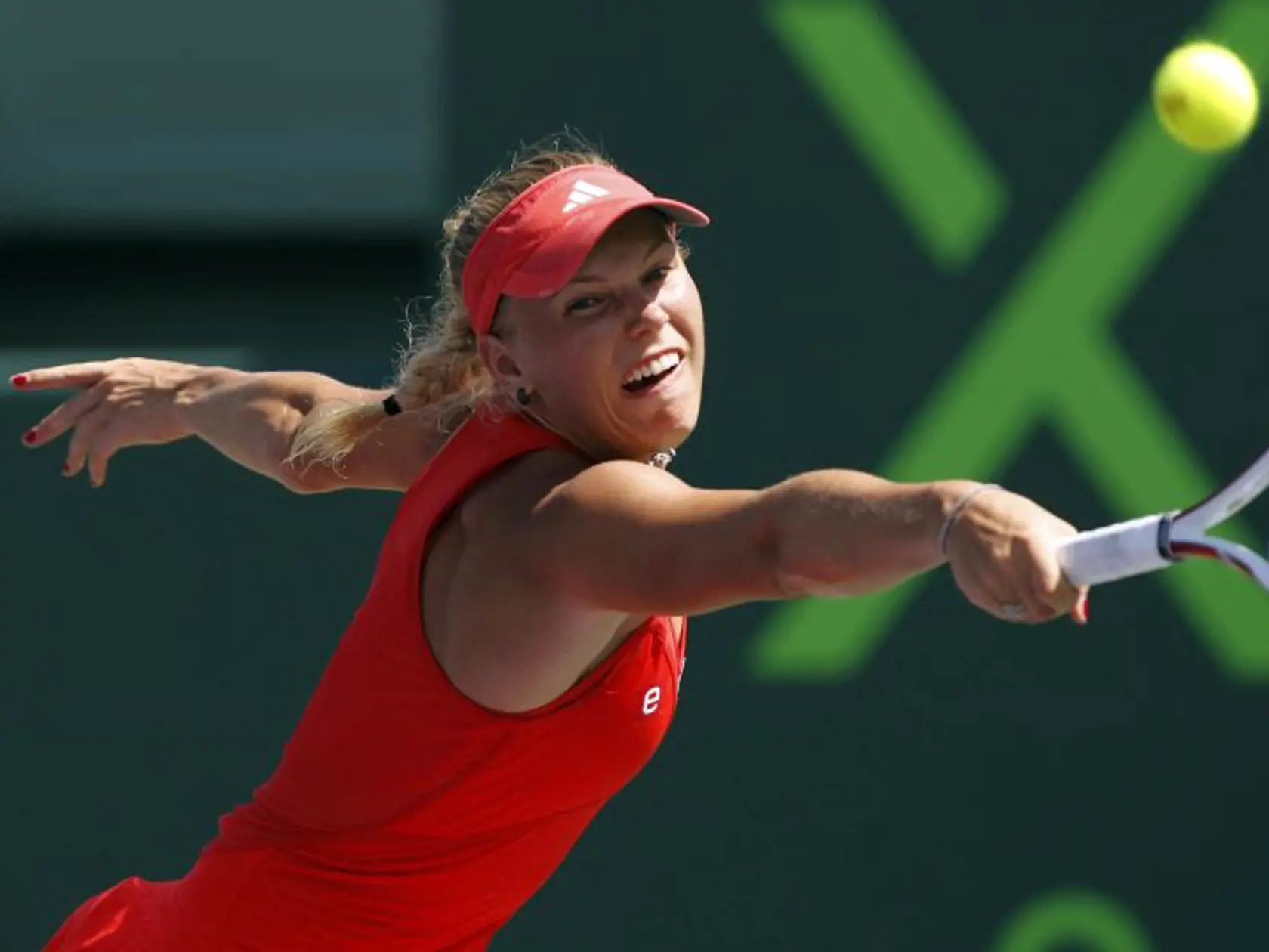 Caroline Wozniacki, of Denmark, returns the ball to Maria Sharapova, of Russia, during the Sony Ericsson tennis tournament, Thursday, March 29, 2012, in Key Biscayne, Fla. Sharapova won the match 4-6, 6-2, 6-4. (AP Photo/Lynne Sladky)