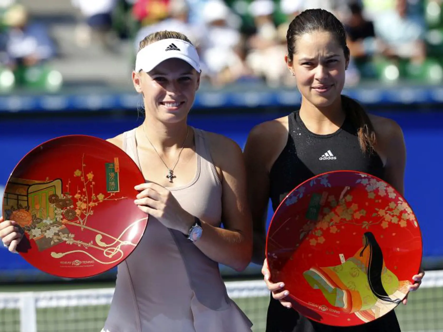 Ana Ivanovic of Serbia, right, and Caroline Wozniacki of Denmark pose for photographers after Ivanovic beat Wozniacki in their final to win the of the Pan Pacific Open Tennis tournament in Tokyo Sunday, Sept.  21, 2014. (AP Photo/Shizuo Kambayashi)