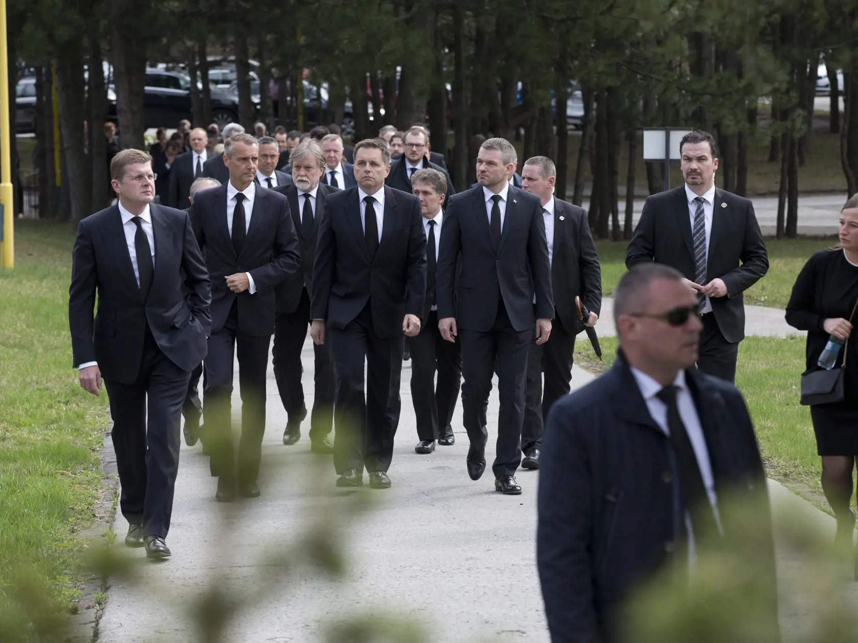 Paparazzi foto pred domom Pavla Pašku v Košiciach. Na fotke pohyb ľudí pred domom a obrad v krematóriu