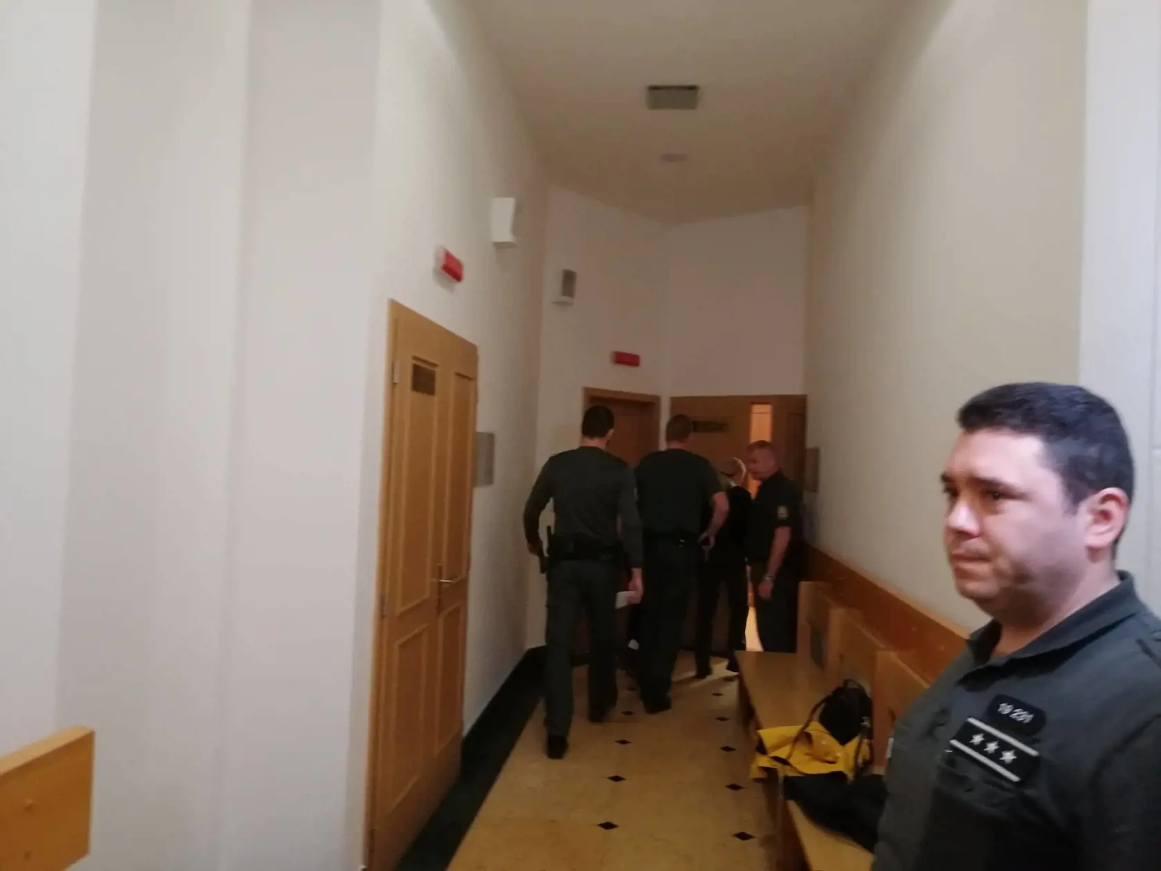 Juditu predvádzajú do pojednávacej miestnosti.