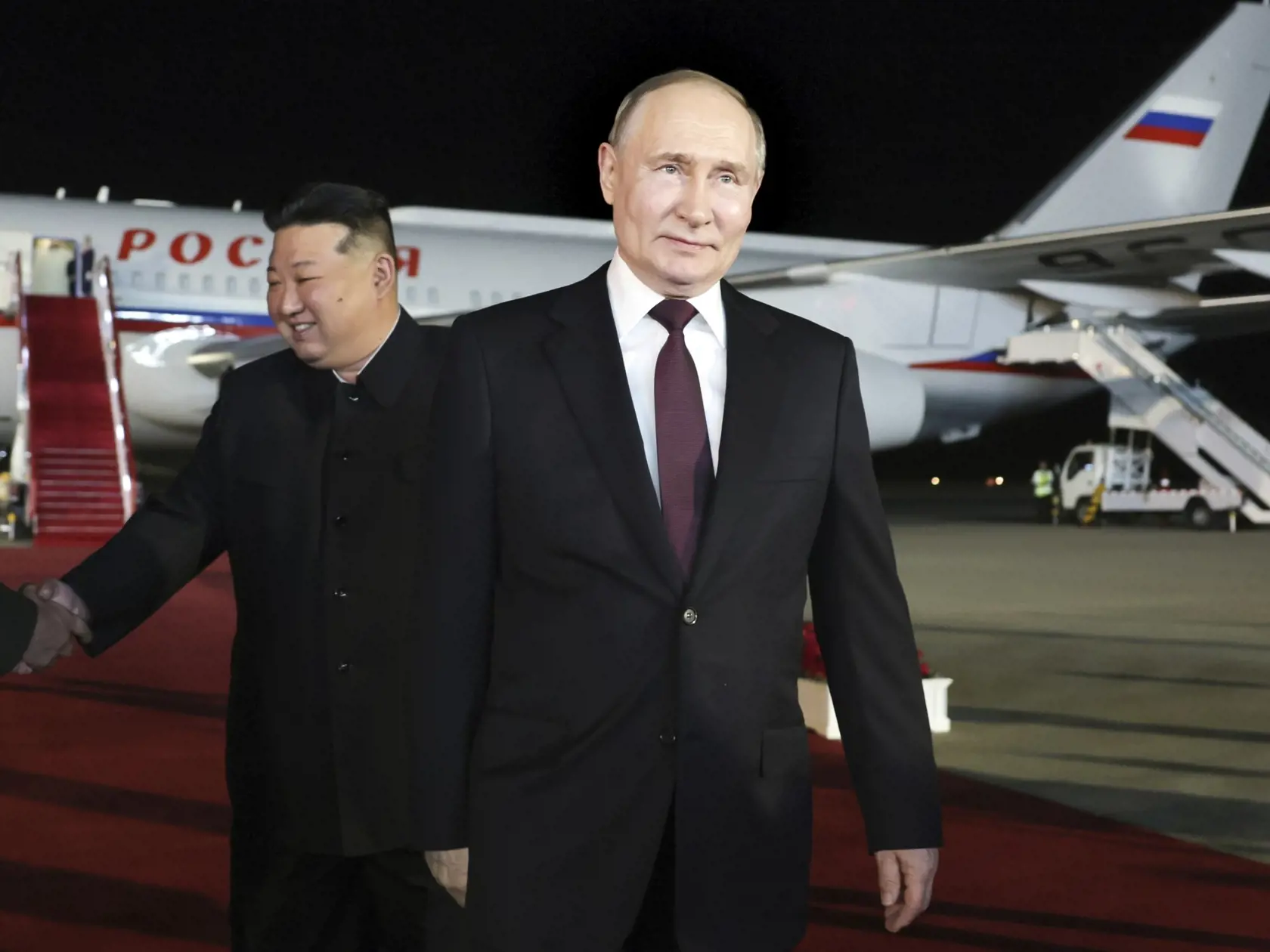 KK6 Pchjongjang - Ruský prezident Vladimir Putin (vpravo) a severokórejský vodca Kim Čong-un sa usmievajú počas stretnutia na letisku v Pchjongjangu 19. júna 2024. Ruský prezident Vladimir Putin pricestoval v stredu v skorých ranných hodinách miestneho času na avizovanú návštevu do Severnej Kórey. FOTO TASR/AP
Russian President Vladimir Putin, right, walks as North Korea's leader Kim Jong Un shakes hands with the Russian delegation during their meeting at the Pyongyang Sunan International Airpor
