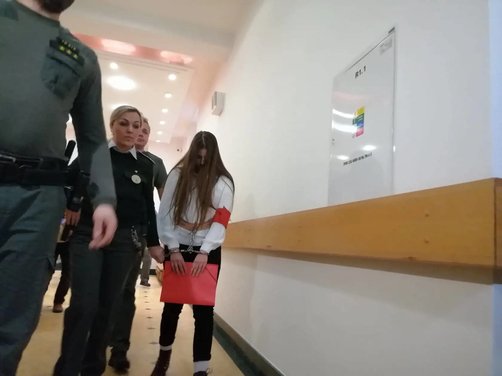 Juditu predvádzajú do pojednávacej miestnosti.
