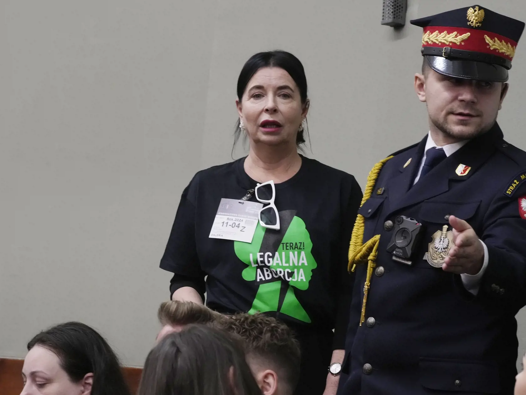 WA 12 Varšava - Aktivistku v tričku s nápisom "Legálne interrupcie hneď" privádza strážnik na jej miesto v poľskom parlamente, ktorého poslanci rokujú o štyroch návrhoch zákona o liberalizácii práva na interrupcie vo Varšave vo štvrtok 11. apríla 2024. Hlasovanie v prvom čítaní je naplánované na piatok. Tradične katolícka krajina má jeden z najreštriktívnejších zákonov o umelom prerušení tehotenstva v Európe. Mnohé ženy si tehotenstvo prerušujú doma interrupčnými tabletkami zaslanými poštou zo z