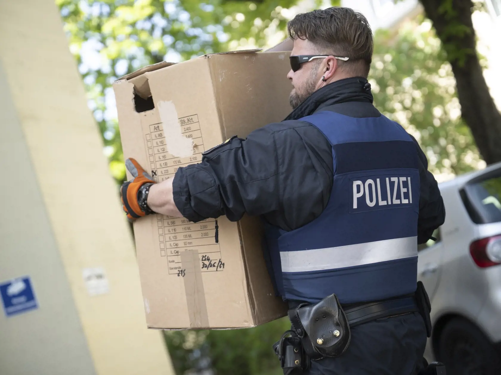 Policajt odnáša krabicu so zaistenými dôkazmi počas rozsiahlej razie proti talianskej mafii Ndrangheta v meste Mainz, spolkovej krajine Porýnie-Falcko na juhozápade Nemecka.