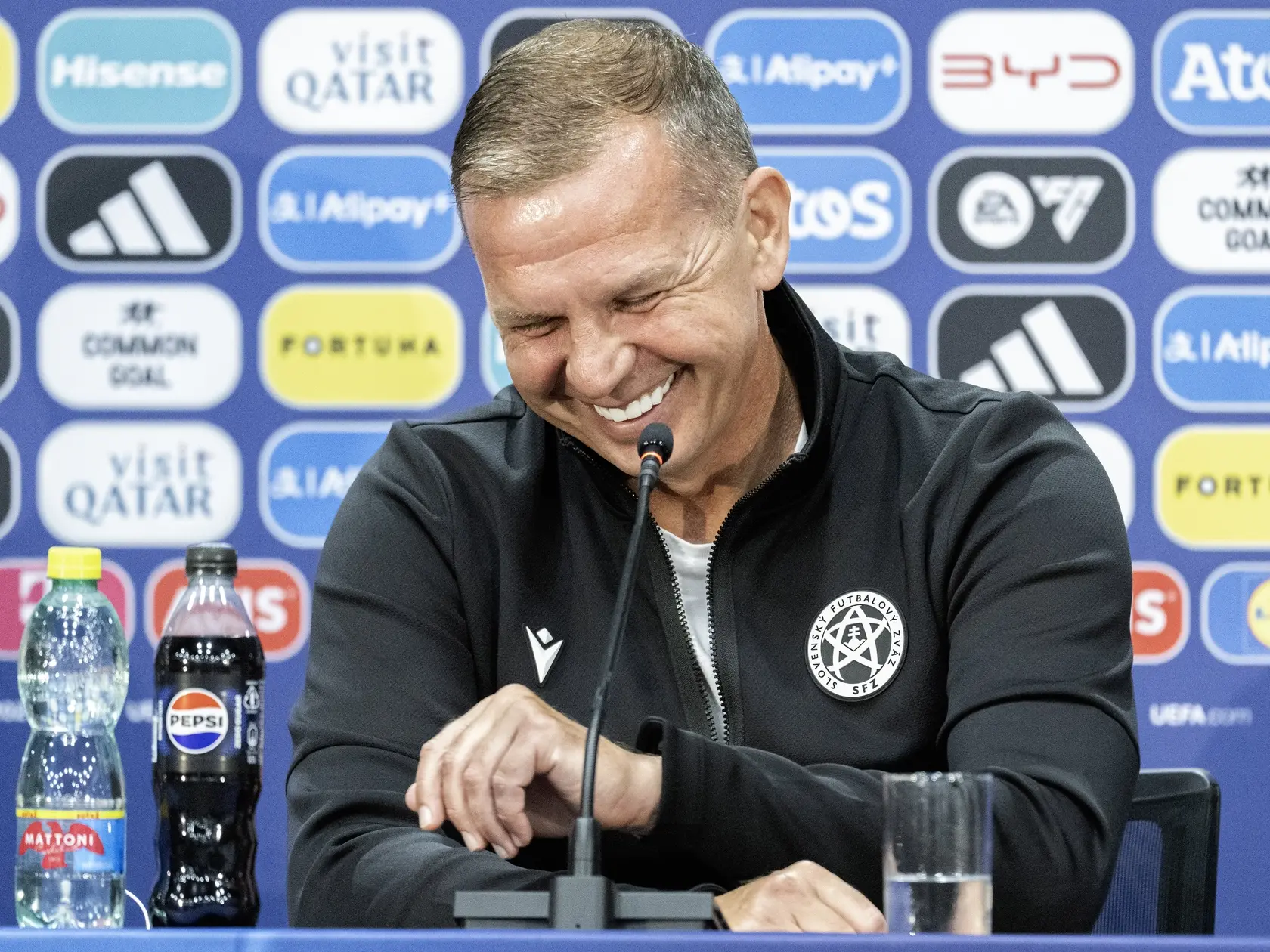 Na snímke tréner slovenskej futbalovej reprezentácie do 21 rokov Jaroslav Kentoš sa usmieva počas tlačovej konferencie red záverečným zápasom A-skupiny Rumunsko - Slovensko na domácich ME hráčov do 21 rokov.