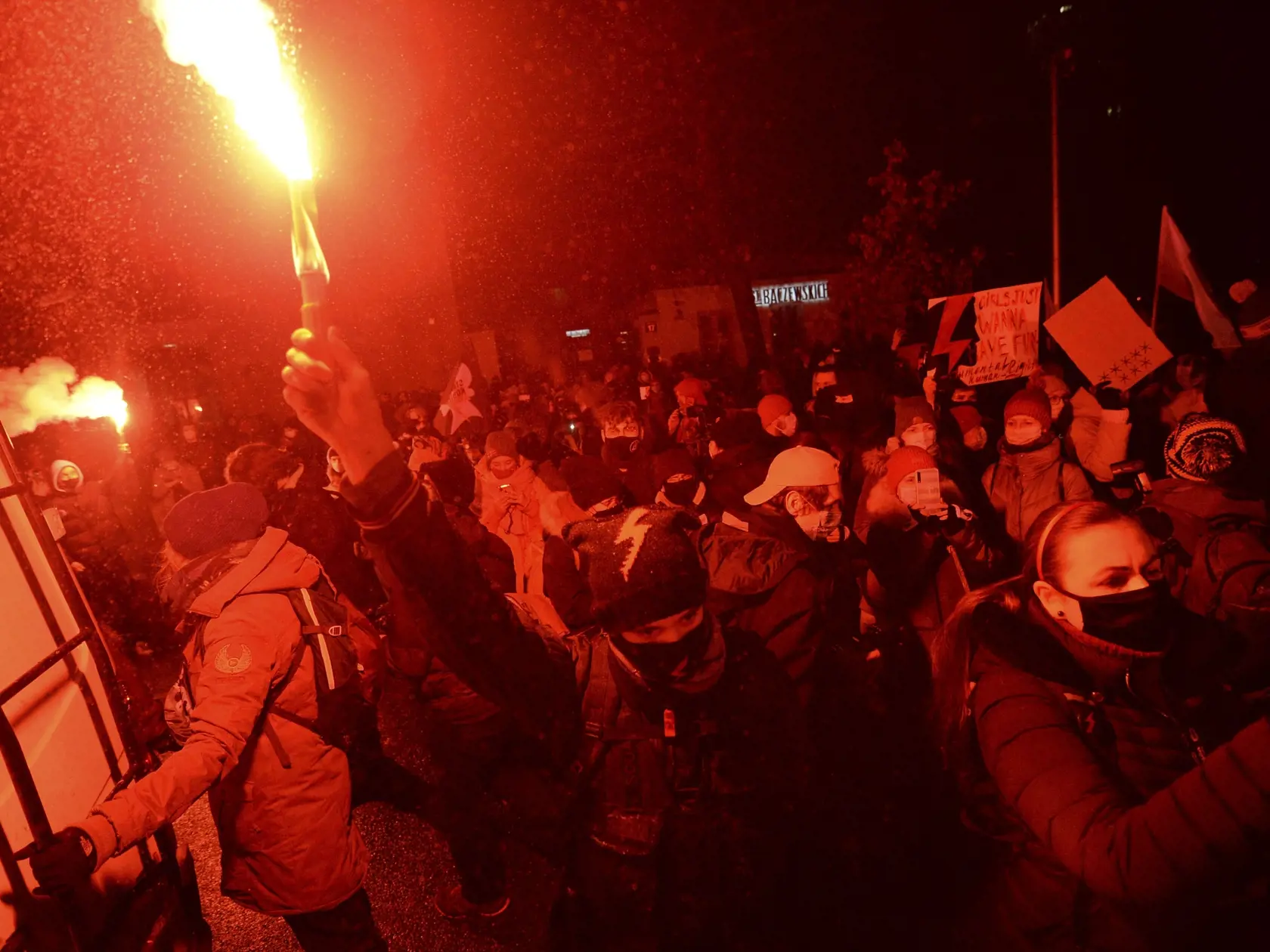 Ľudia protestujú so svetlicami proti poľskému zákonu o interrupciách vo Varšave.