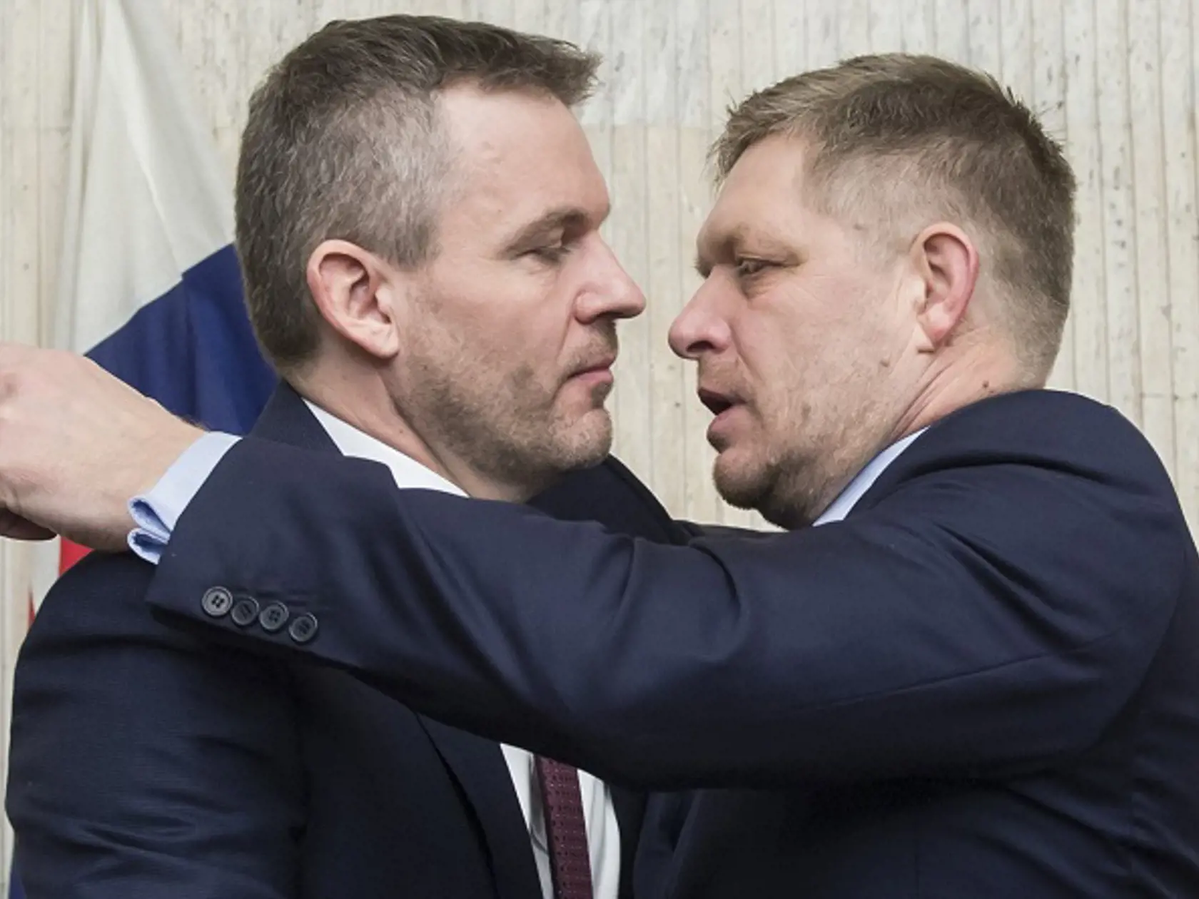 Na snímke vpravo odchádzajúci premiér SR Robert Fico a vľavo dezignovaný premiér Peter Pellegrini sa obíjmajú po skončení 94. rokovania vlády SR 22. marca 2018 v Bratislave.  FOTO TASR - Martin Baumann


