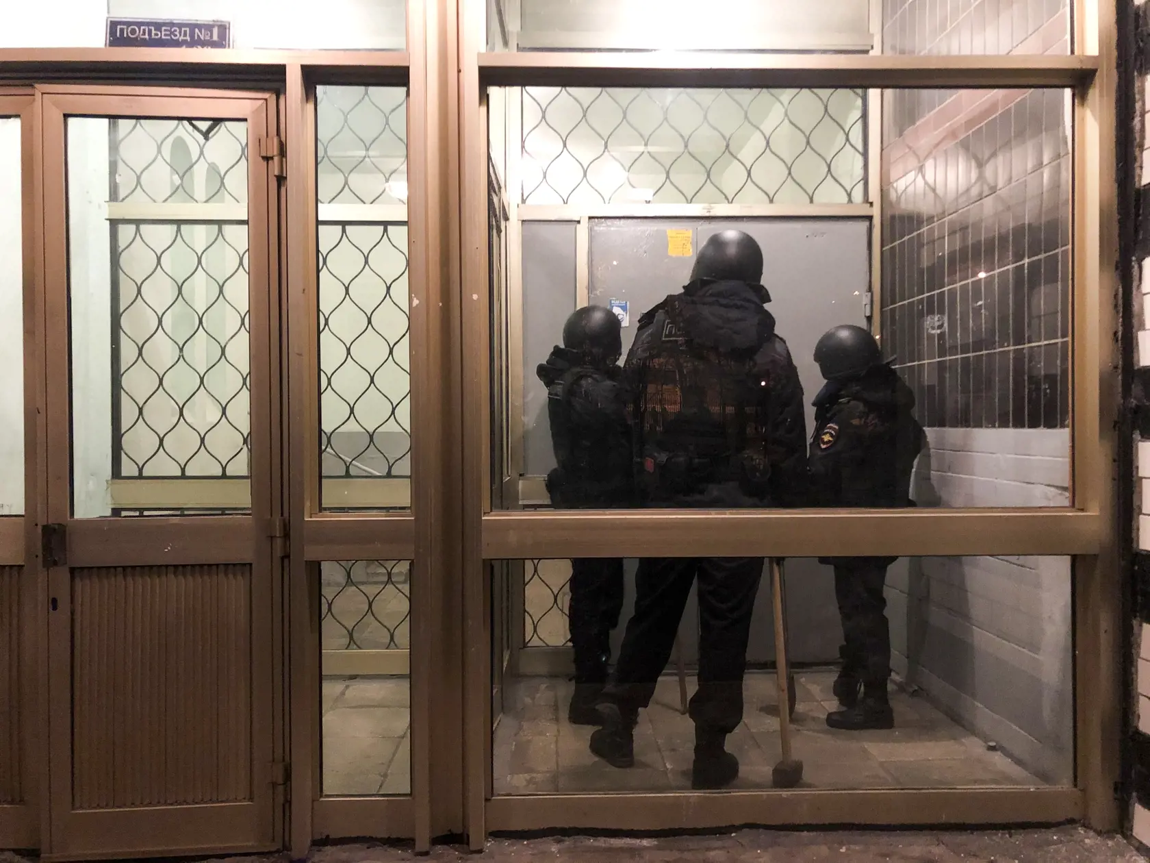KK15 Moskva - Policajti stoja pred dvermi bytovky, v ktorej býva opozičný politik Alexej Navaľnyj v Moskve 27. januára 2021. Ruská polícia v stredu prehľadala moskovský byt opozičného politika Alexeja Navaľného. Domová prehliadka súvisí s vyšetrovaním možného porušenia "hygienických a epidemiologických nariadení," priblížil na Twitteri Navaľného spolupracovník Ivan Ždanov, píše agentúra AFP.  Ždanov tiež informoval o policajnej prehliadke v kancelárii Navaľného protikorupčnej nadácie a v ďalšom 