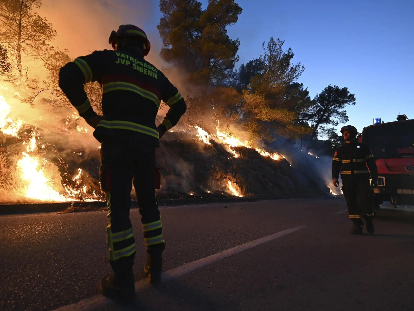 Hasiči sledujú požiar v chorvátskom Zatone 13. júla 2022.