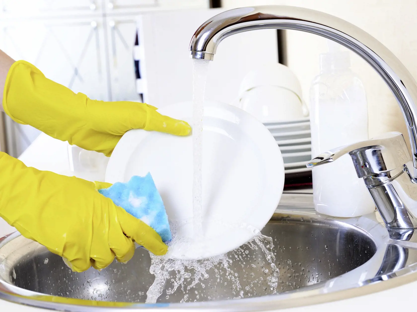 Close,Up,Hands,Of,Woman,Washing,Dishes,In,Kitchen