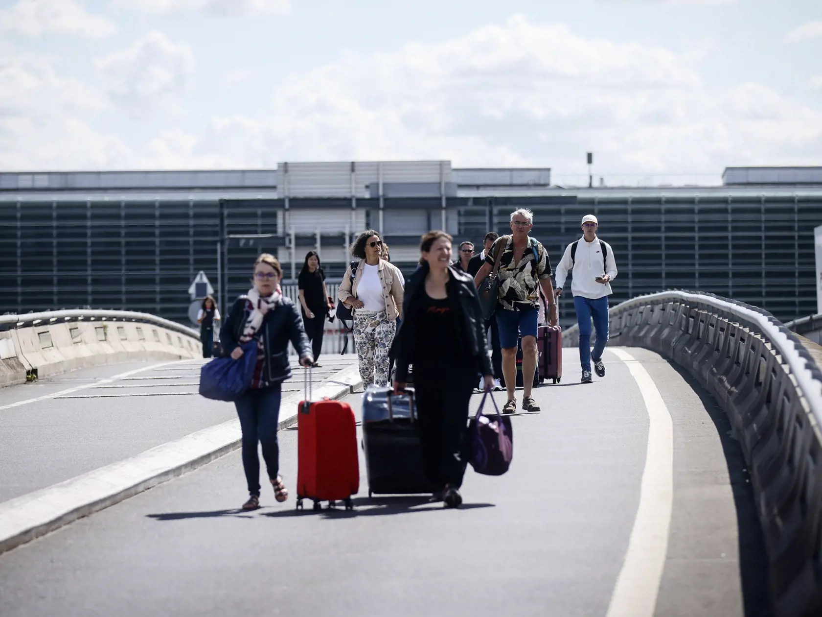 JB 23 Paríž - Cestujúci prichádzajú pešo na letisko Roissy - Charles de Gaulle, severne od Paríža 1. júla 2022 počas štrajku francúzskych odborárov na termináli. Viaceré lety dnes zrušili pre štrajk francúzskych odborov na letisku v Paríži ako aj na ďalších francúzskych letiskách. Protestujúci odporári žiadajú zvýšenie platov v súvislosti so zrýchlením inflácie. FOTO TASR/AP

Travelers arrive on foot at Roissy-Charles de Gaulle airport while airport workers demonstrate, Friday, July 1, 2022 at R