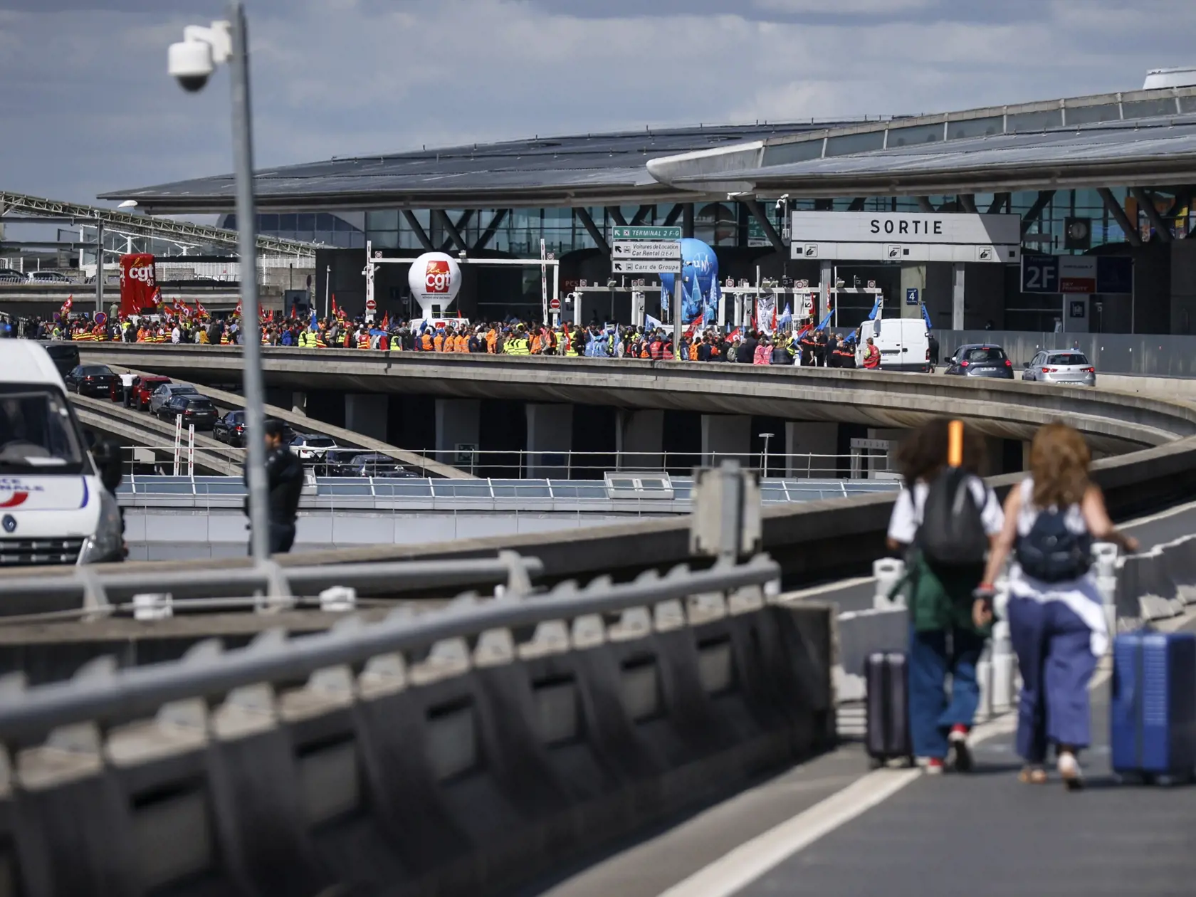 JB 21 Paríž - Cestujúci prichádzajú na letisko Roissy - Charles de Gaulle, severne od Paríža 1. júla 2022 počas štrajku francúzskych odborárov na termináli (vľavo). Viaceré lety dnes zrušili pre štrajk francúzskych odborov na letisku v Paríži ako aj na ďalších francúzskych letiskách. Protestujúci odporári žiadajú zvýšenie platov v súvislosti so zrýchlením inflácie. FOTO TASR/AP

Travelers arrive on foot at Roissy-Charles de Gaulle airport while airport workers demonstrate, left, Friday, July 1, 