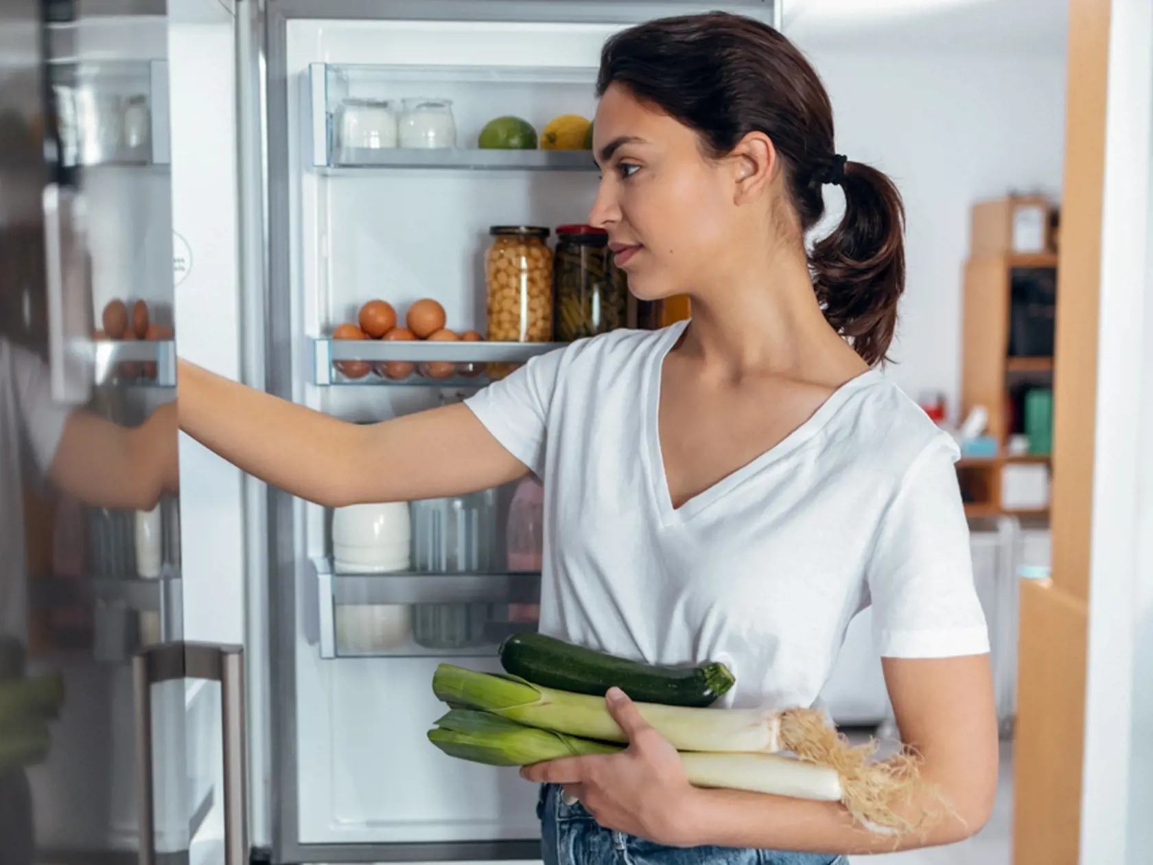 Shoot of beautiful young woman taking some healthy food from the fridge in the kitchen at home