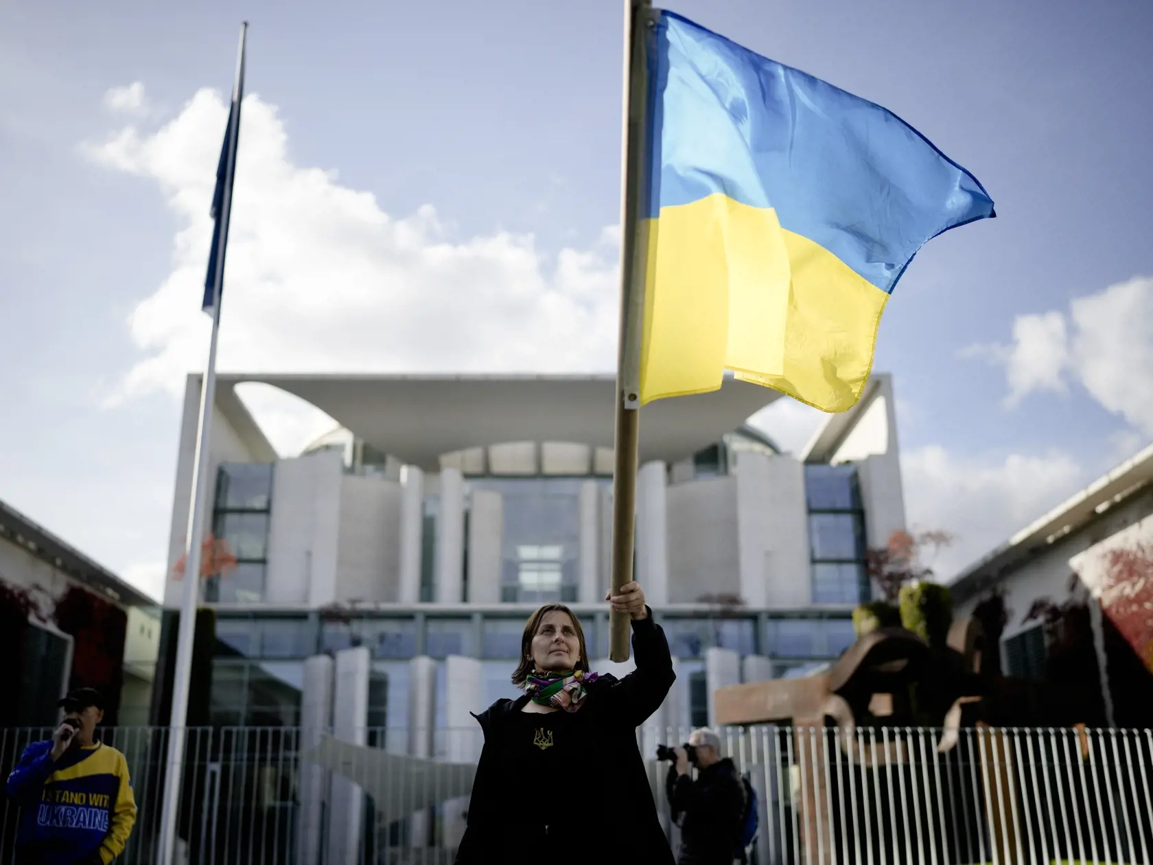 Na snímke žena máva ukrajinskou vlajkou počas protestu proti vojne na Ukrajine pred budovou, v ktorej sídli úrad nemeckého kancelára v Berlíne 11. októbra 2022.