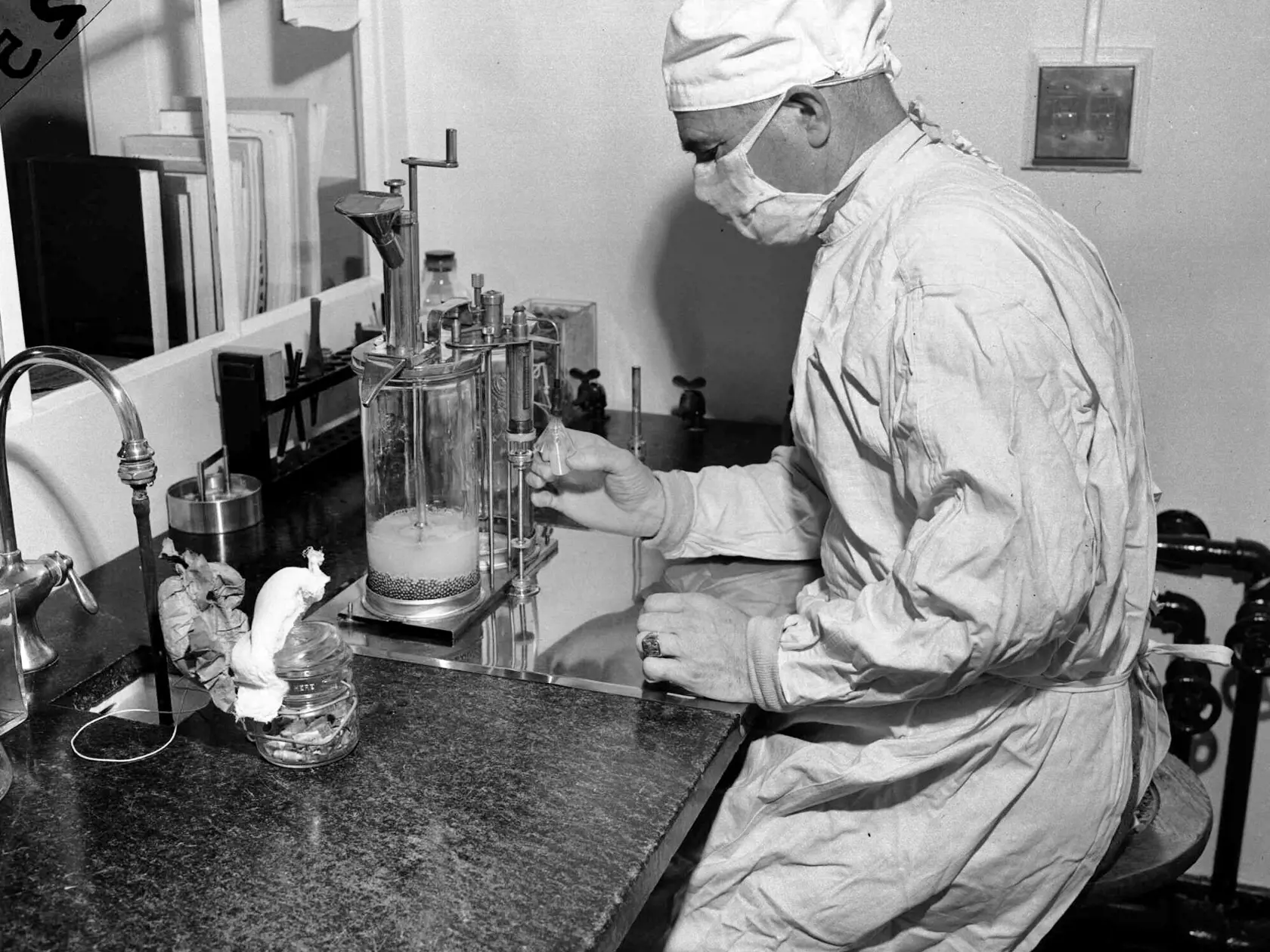 Na archívnej snímke z 2. decembra 1947 Charles D. Brown plní injekčnú striekačku vakcínou BCG proti tuberkulóze (TBC) v štátnom laboratóriu v americkom meste Albany. Vedci odprašujú niekoľko desiatok rokov starých vakcín proti TBC a detskej obrne, aby zistili, či nie sú účinné na ochorenie COVID-19, pokiaľ sa neobaví vakcína na celosvetovú nákazu spôsobenou koronavírusom SARS-CoV-2.