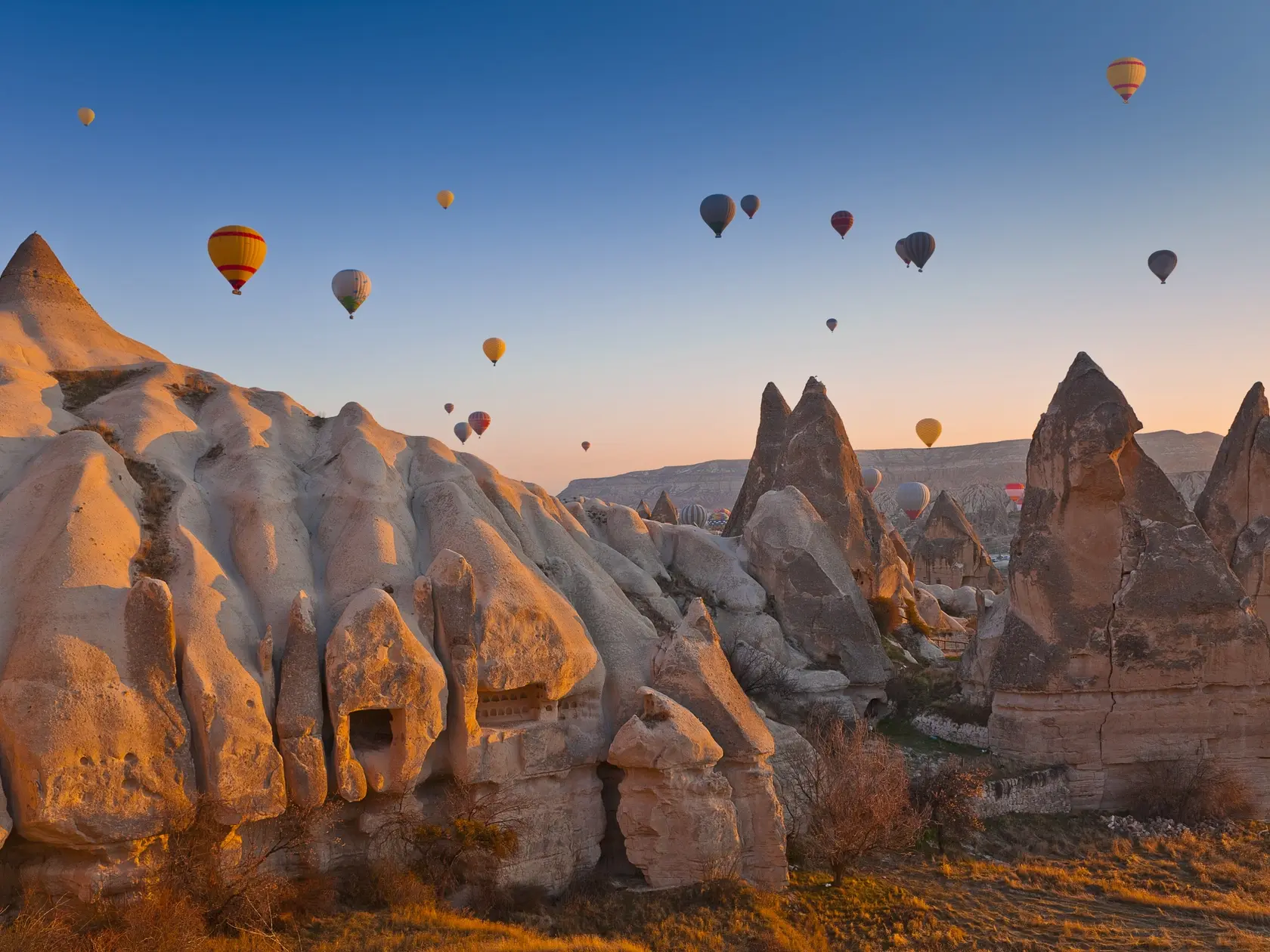 Hot Air Balloons rise up over the Goreme Valley in Cappadocia, Turkey