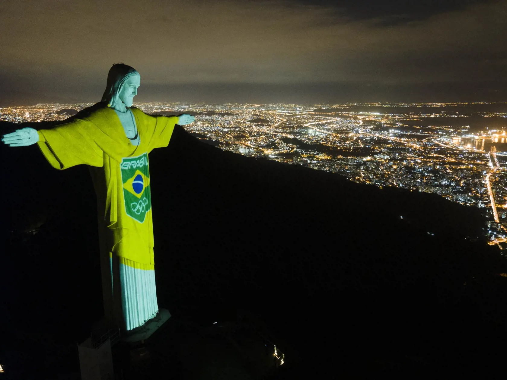 WA 11 Rio de Janeiro - Farby brazílskeho olympijského tímu premieta brazílsky olympijský výbor na sochu Krista Vykupiteľa v Riu de Janeiro pri príležitosti sto dní do začiatku odložených letných olympijskych hier v Tokiu v stredu 14. apríla 2021. Olympiádu museli v dôsledku pandémie ochorenia COVID-19 presunúť z minulého roka na nový termín, športovci budú bojovať o cenné kovy od 23. júla do 8. augusta 2021. FOTO TASR/AP
The colors of the Brazilian Olympic team are projected on the statue of C