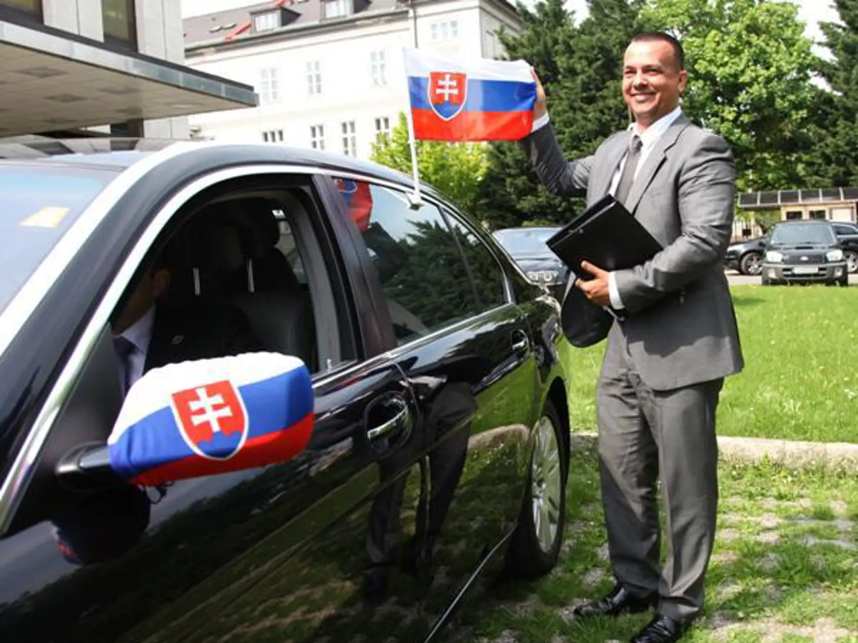 Minister hospodárstva Juraj Miškov odchádza z úradu vlády svojou limuzínou ozdobenou slovenskými vlajkami