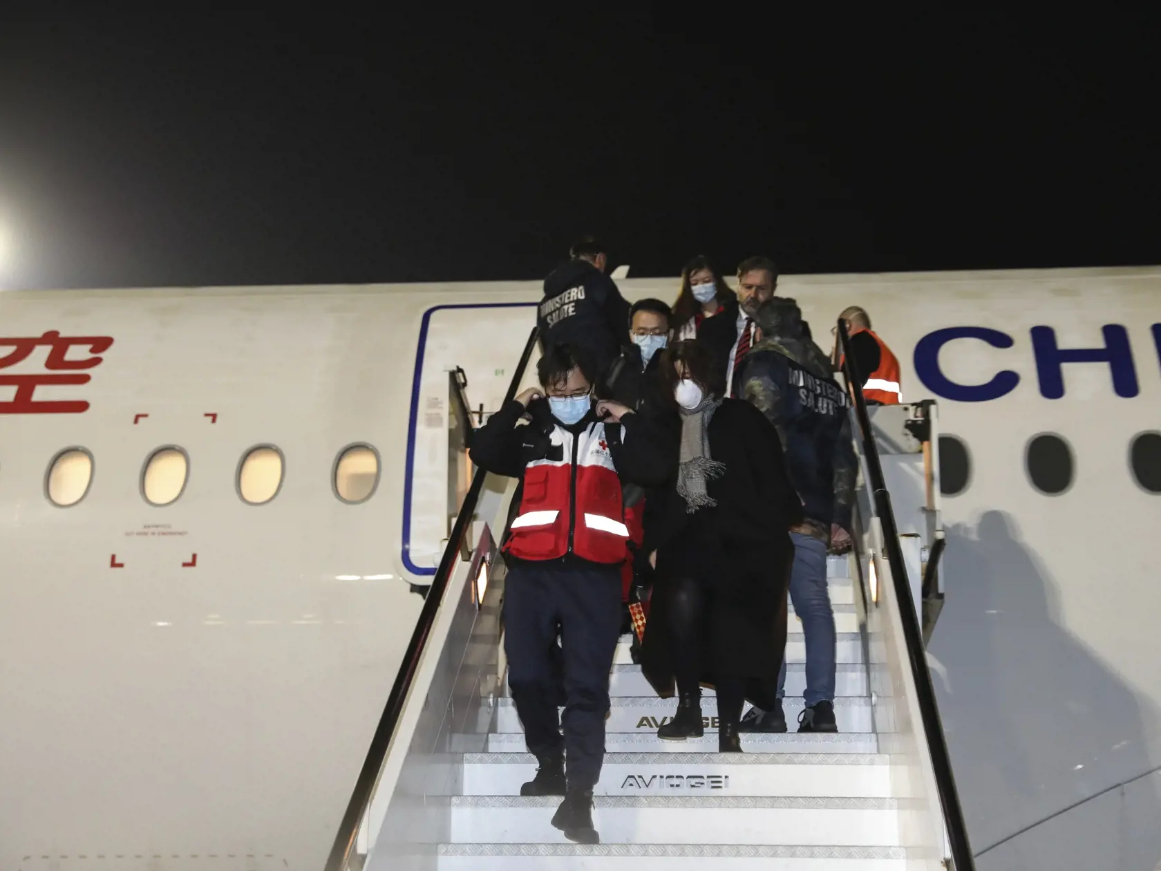 KK6 Rím - Tím zdravotníkov z Číny vychádza z lietadla po prílete na letisko Fiumicino v Ríme 12. marca 2020. Tím zdravotníkov z Číny pricestoval vo štvrtok do Ríma, aby talianskym kolegom pomohol prekonať epidémiu koronavírusu. Ako v piatok informovala agentúra Sinchua, do Talianska pricestovali charterovým letom a spolu s 30 tonami zdravotníckeho materiálu a ochranných pomôcok. Doviezli napr. dýchacie prístroje, monitory a defibrilátory na zariadenie jednotky intenzívnej starostlivosti pre paci