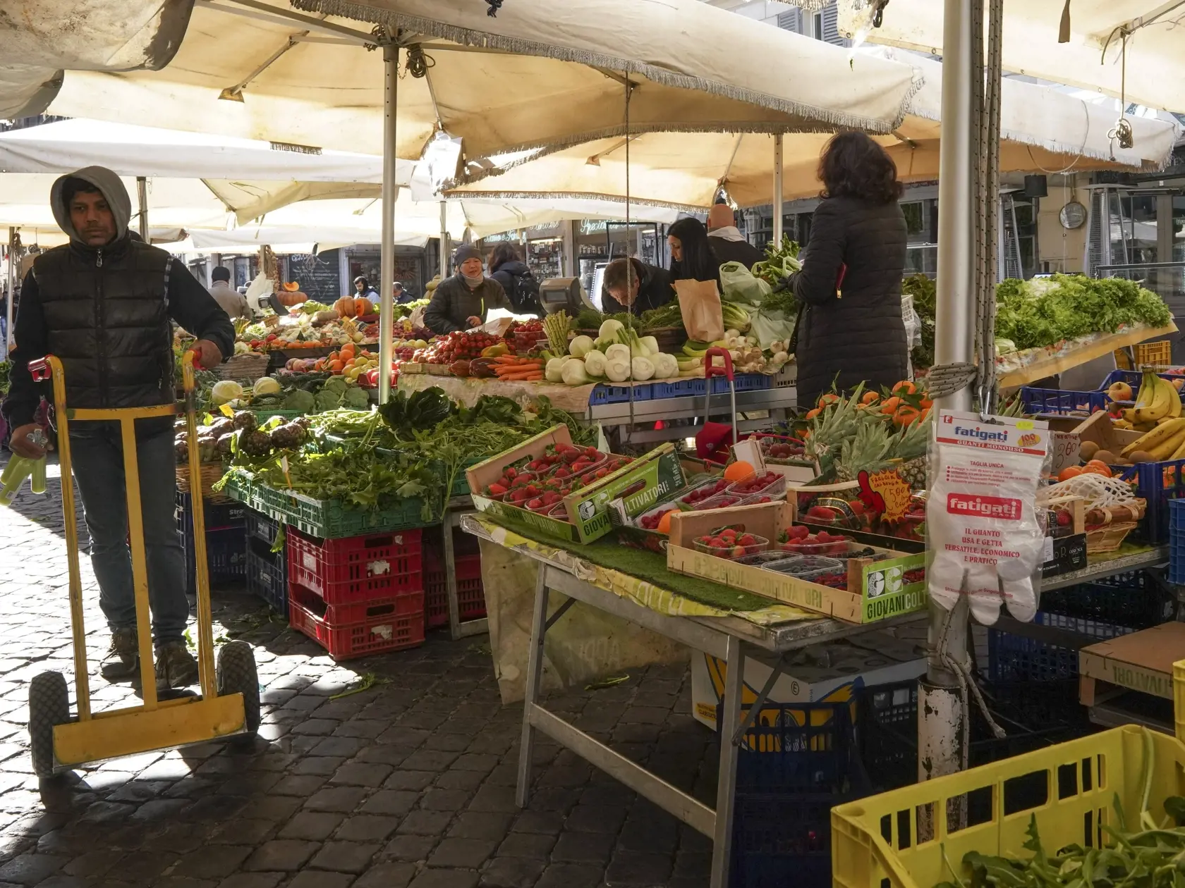 MIK 17 Rím - Muž tlačí vozík na trhu Campo dei Fiori  kde na ovocie a zeleninu majé ochranné rukavice, v Ríme 10. marca 2020. Talianska vláda ubezpečuje svojich občanov, že supermarkety zostanú otvorené a zásobené aj po prepuknutí paniky po rozsiahlych antivírusových opatreniach. FOTO TASR/AP

A man pushes a trolley as gloves hang at a fruit and vegetable stand at Campo dei Fiori open-air market, in Rome, Tuesday, March 10, 2020. The Italian government is assuring its citizens that supermarkets 