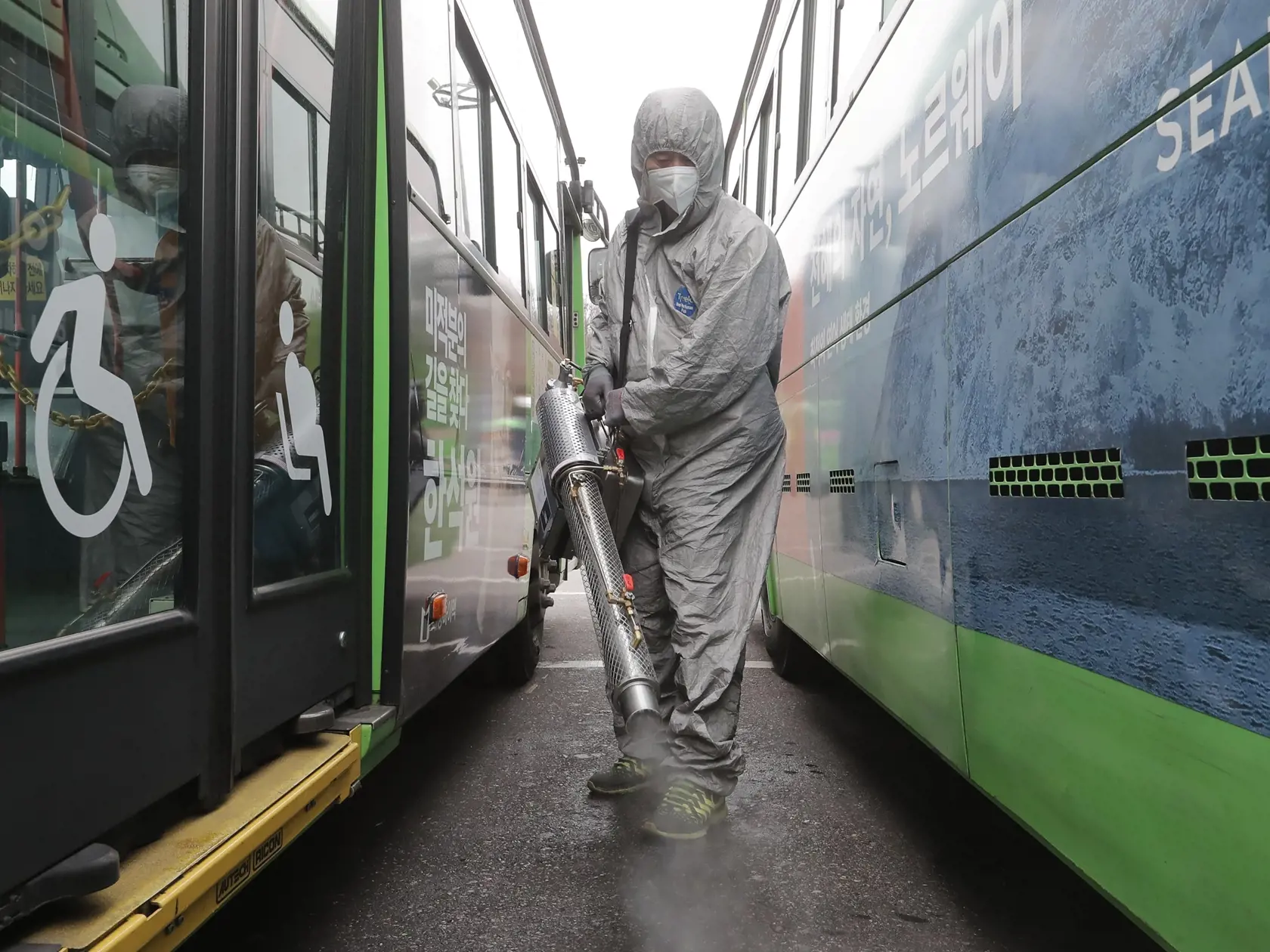 MIK 16 Soul - Pracovník v ochrannom odeve dezinfikuje proti koronavírusu autobusové parkovisko v juhokórejskom Soule 26. februára 2020.