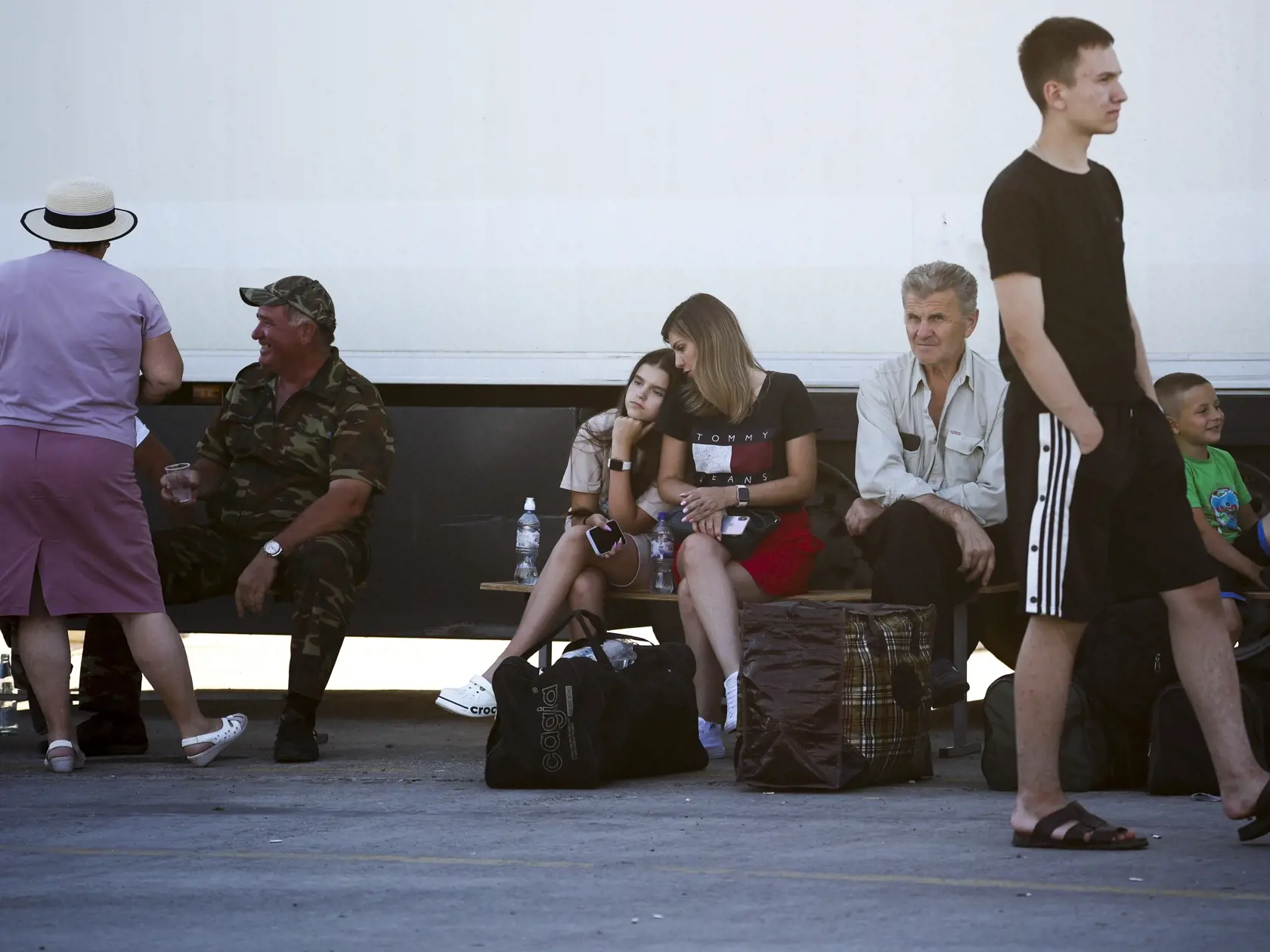 Ľudia čakajú na trajekt na Krym pri ruskej obci Iľjič v Krasnodarskej oblasti 17. júla 2023. Ruskí turisti, ktorých ruské a okupačné úrady nabádajú, aby po najnovšom poškodení Krymského mosta cestovali na Krymský polostrov cez okupované územia Ukrajiny, môžu brániť zásobovaniu ruských jednotiek na južnom fronte.