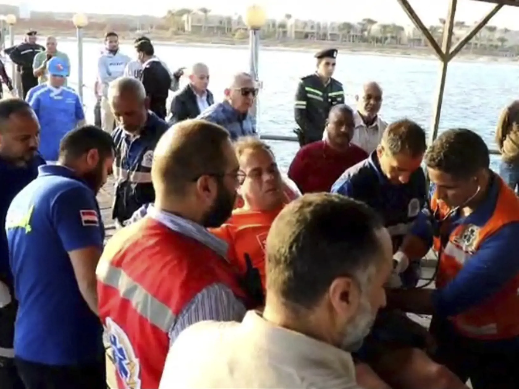 Záchranári nesú preživšieho po potopení turistickej lode v Červenom mori.