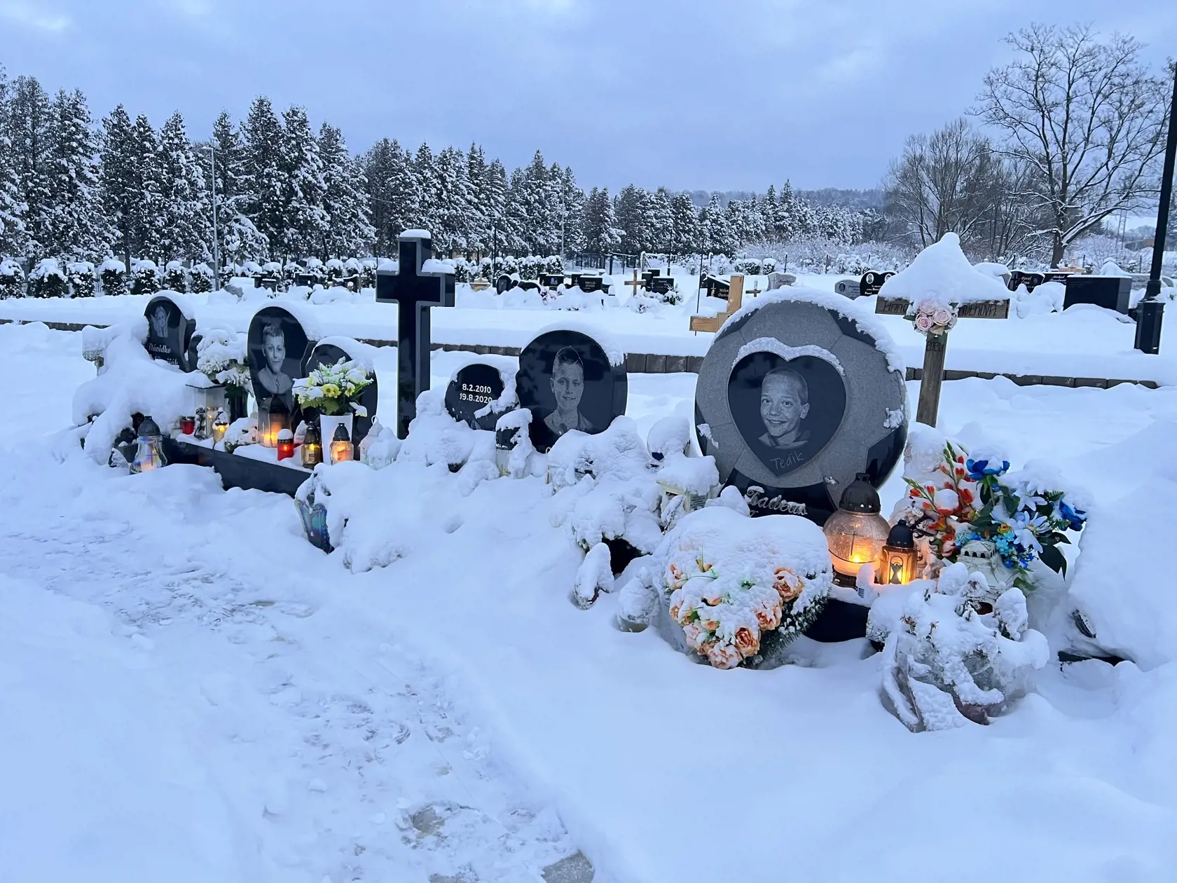 Hrobčeky štyroch malých futbalistov sú stále krásne udržiavané. Ani návaly snehu nezabránili ich príbuzných zapáliť im tam sviečku.