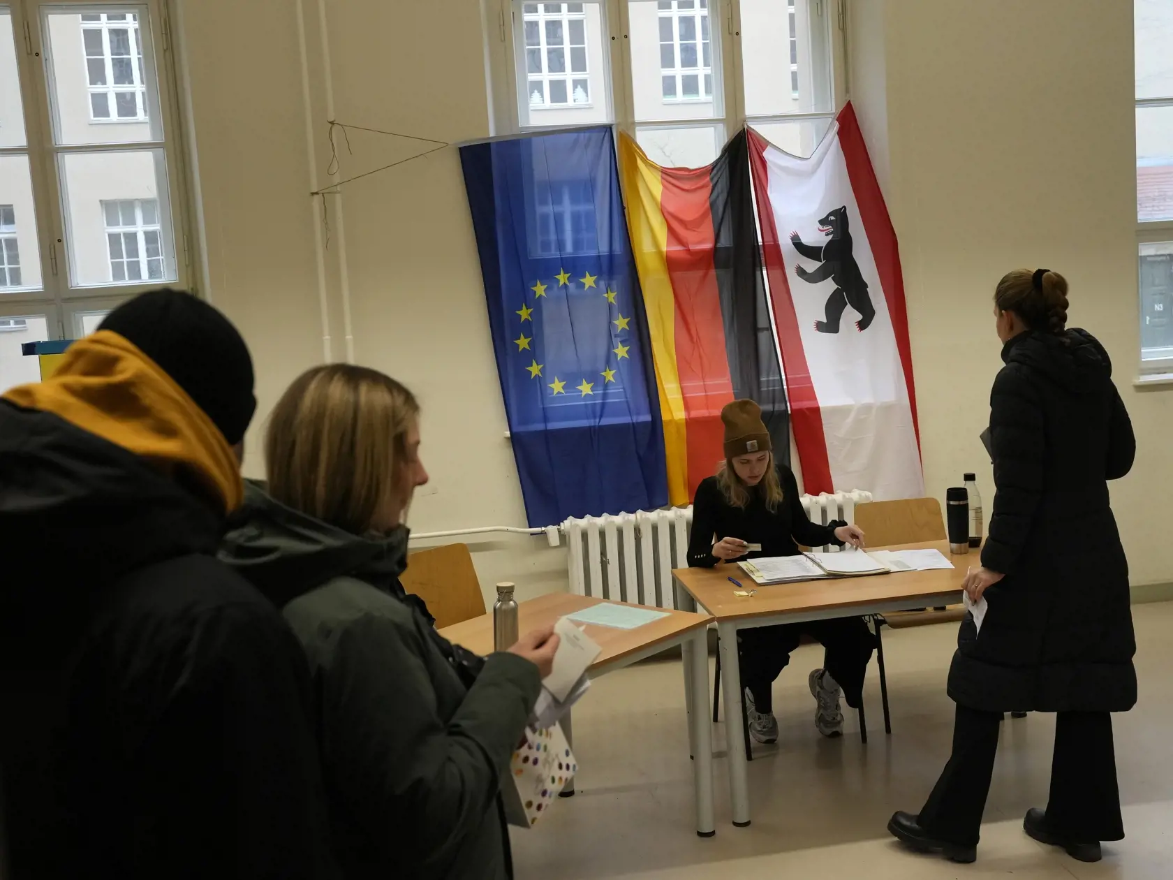 Voliči sa pripravujú na hlasovanie vo volebnej miestnosti počas predčasných parlamentných volieb v Nemecku v nedeľu 23. februára 2025 v Berlíne.