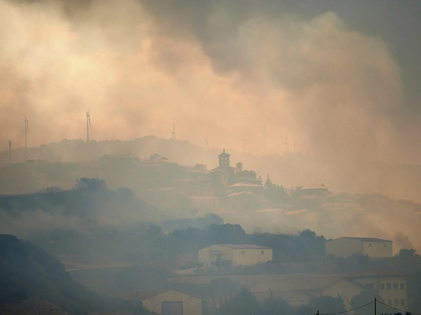 WA 38 San Martin de Unx - Dym zahaľuje mesto San Martin de Unx na severe Španielska počas lesných požiarov v nedeľu 19. júna 2022.