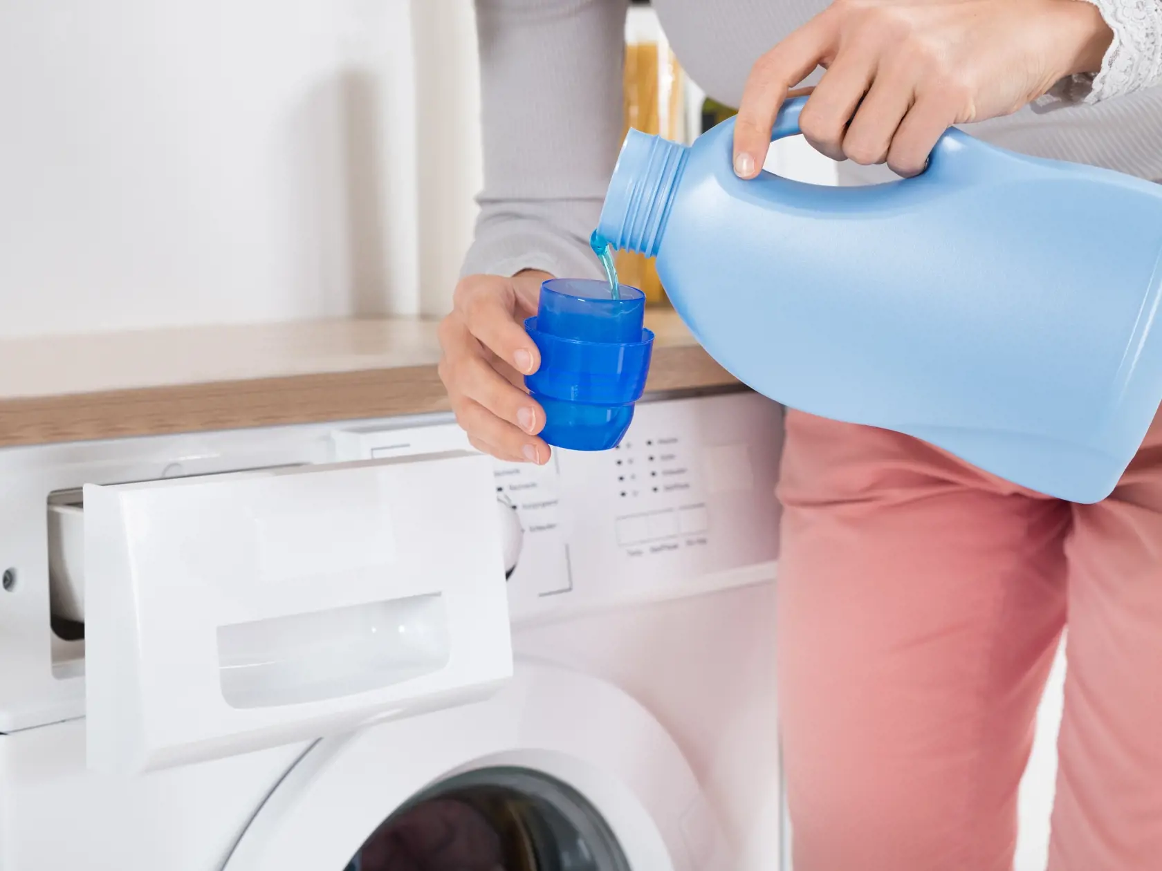 Close-up,Of,Female,Hands,Pouring,Detergent,In,The,Blue,Bottle
