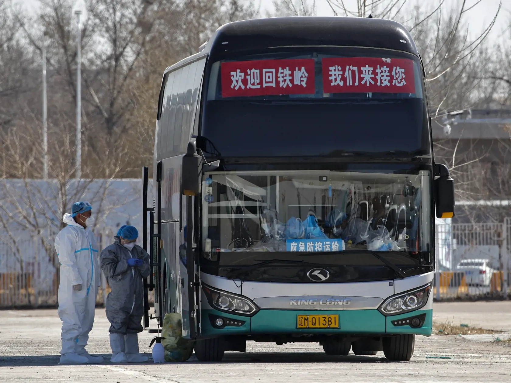 KK14 Peking - Pracovníci v ochranných odevoch stoja pred autobusom pred novým čínskym medzinárodným výstavným centrom, ktoré slúži na kontrolu ľudí prichádzajúcich zo zahraničia 17. marca 2020 v Pekingu. Za uplynulý deň nahlásili v Číne 13 ďalších úmrtí na ochorenie spôsobené koronavírusom a 21 nových infikovaných. Z nich až dvadsiatim zistili ochorenie pri príchode do krajiny a sú tak v oficiálnej štatistike vedení ako "importované prípady". Peking medzitým sprísnil karanténne opatrenia pre ces